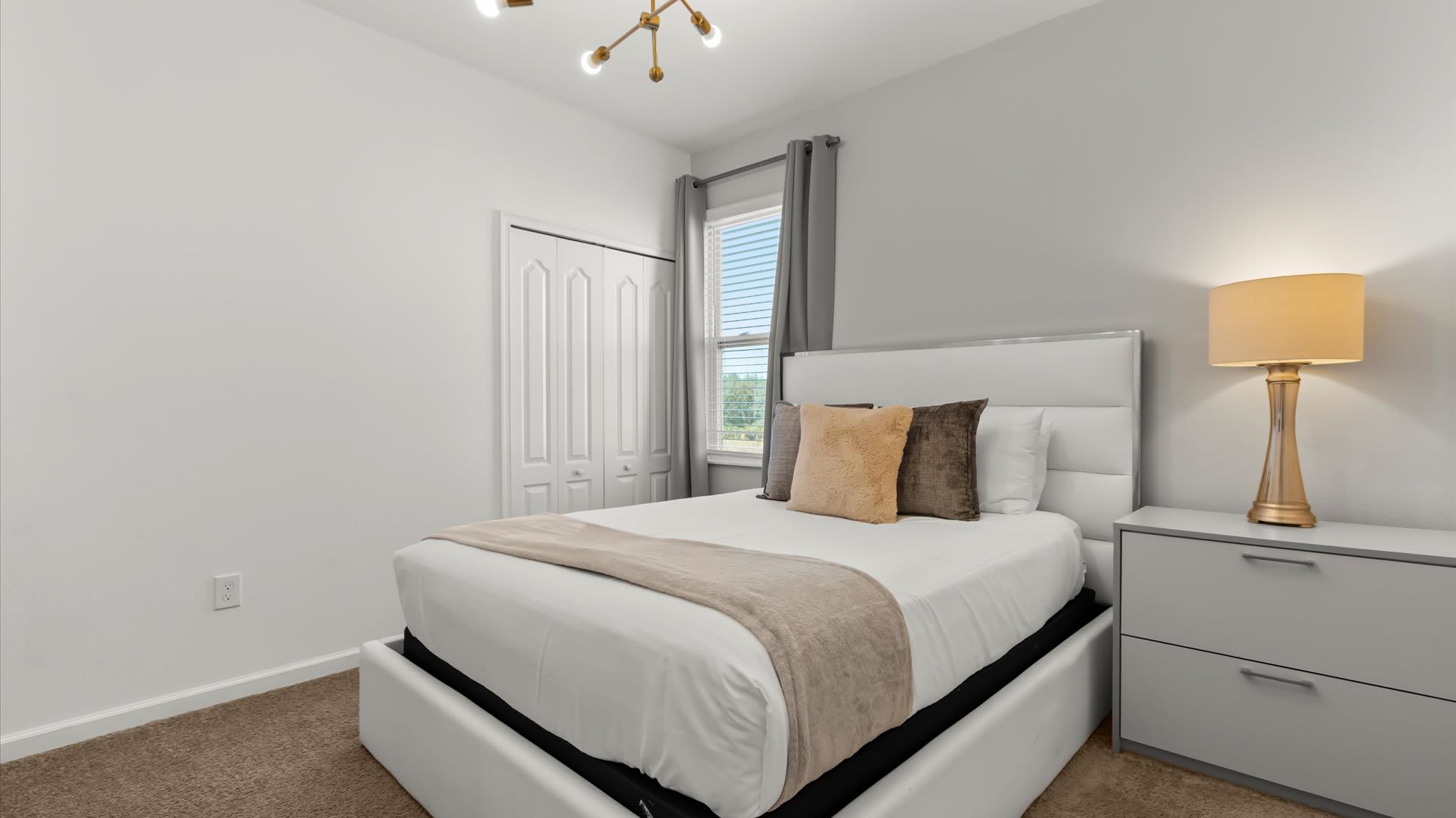 Stylish queen bedroom featuring warm lighting and a modern design.