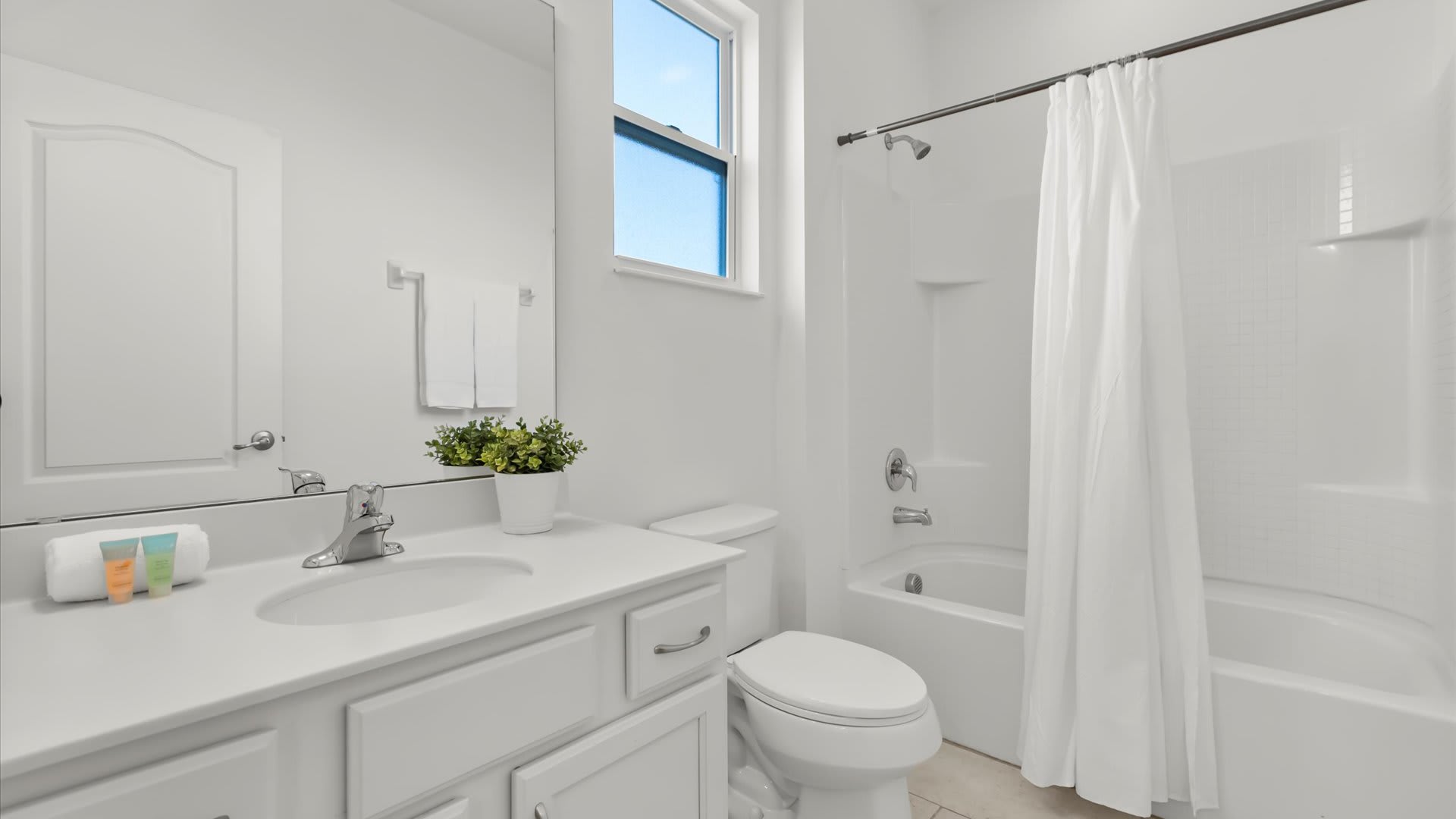 Crisp modern bathroom with shower and tub combo and a fresh white palette.