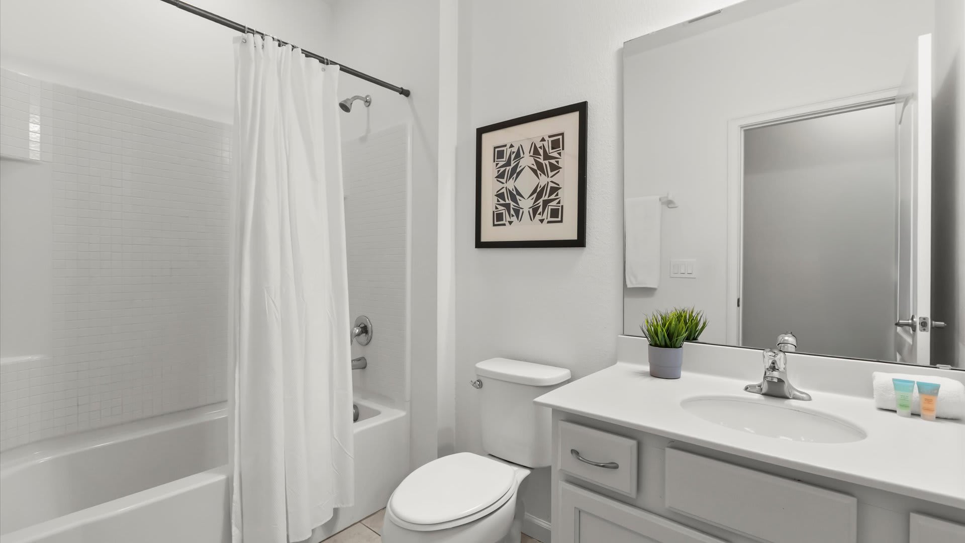 Full bathroom with generous counter space and shower + tub combo.