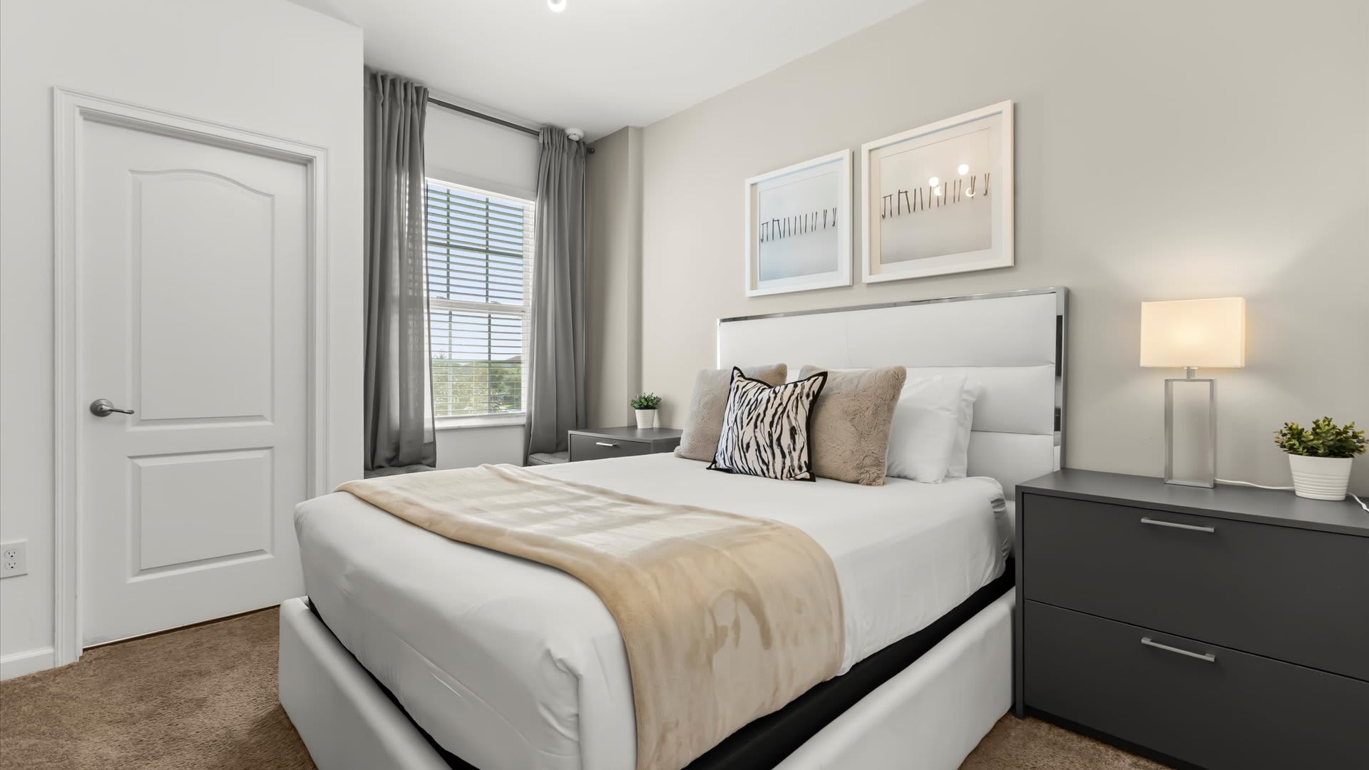 Queen bedroom with soothing tones and large windows.
