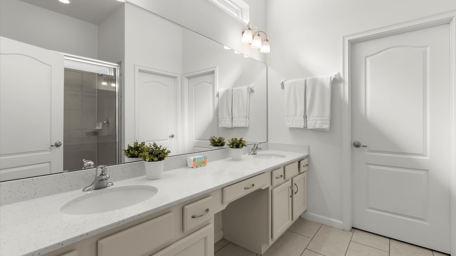 Full bathroom with wide vanity mirror and great lighting.
