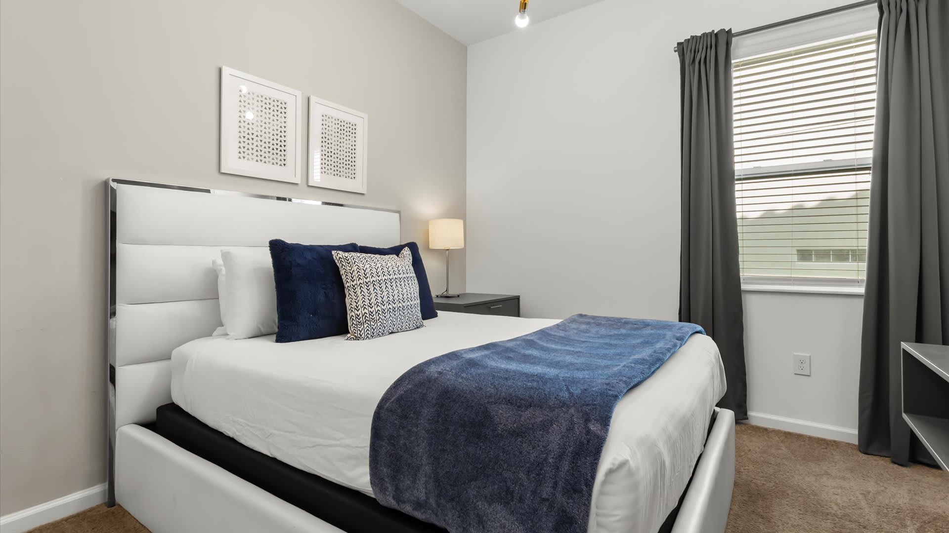 Queen bedroom with calming beige and navy palette.