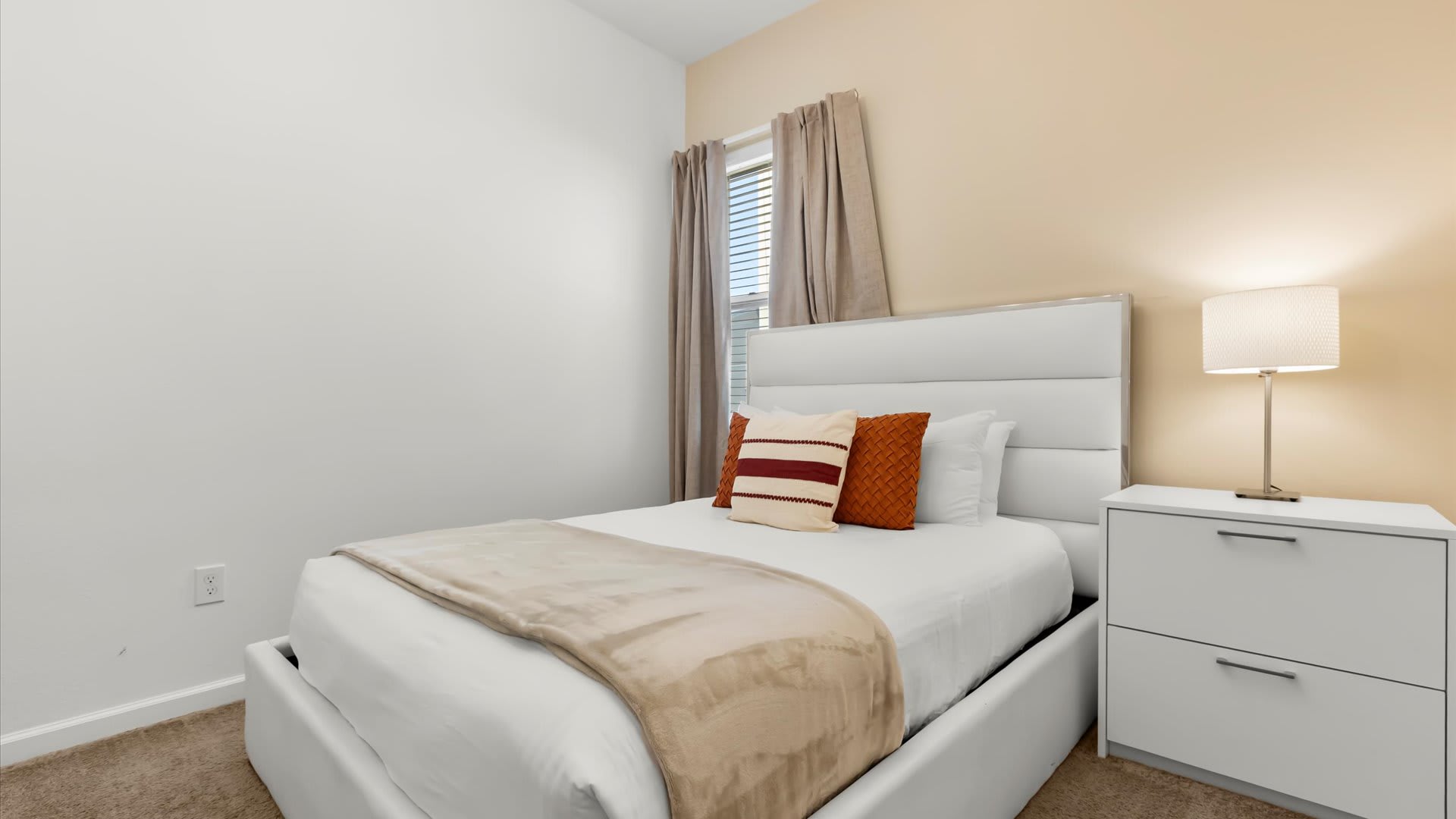 Queen bedroom with reading lamp and serene décor.