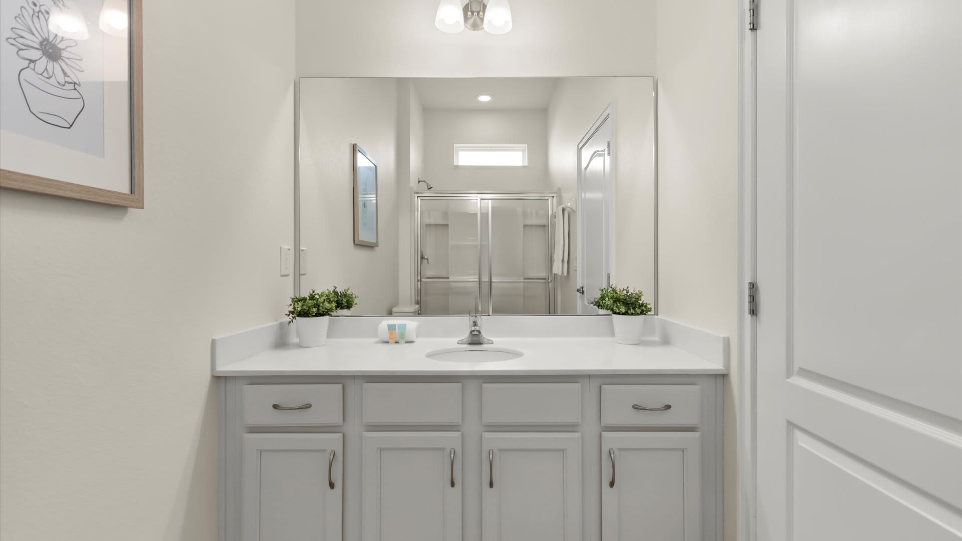 Ensuite bathroom with a bright vanity and a full shower.
