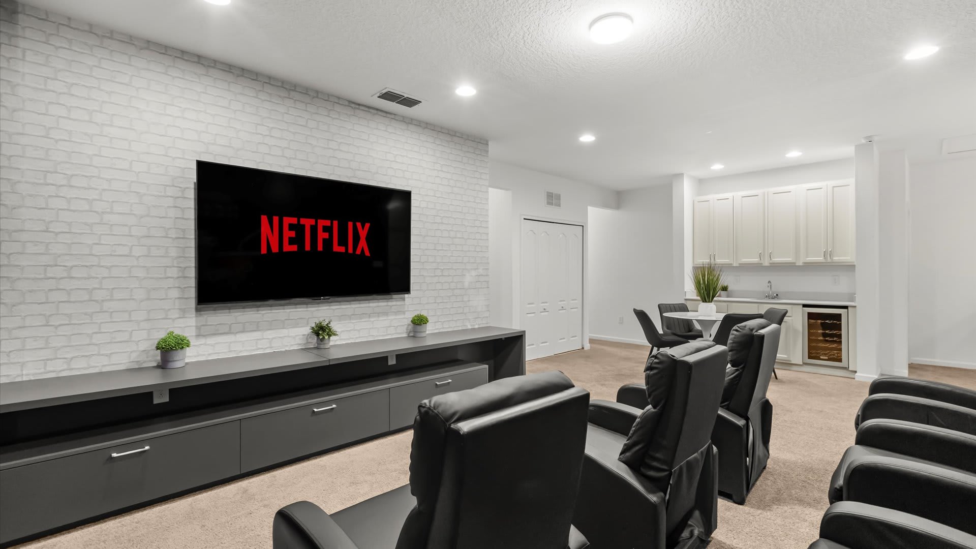 Private cinema room with theatre seating and immersive screen.