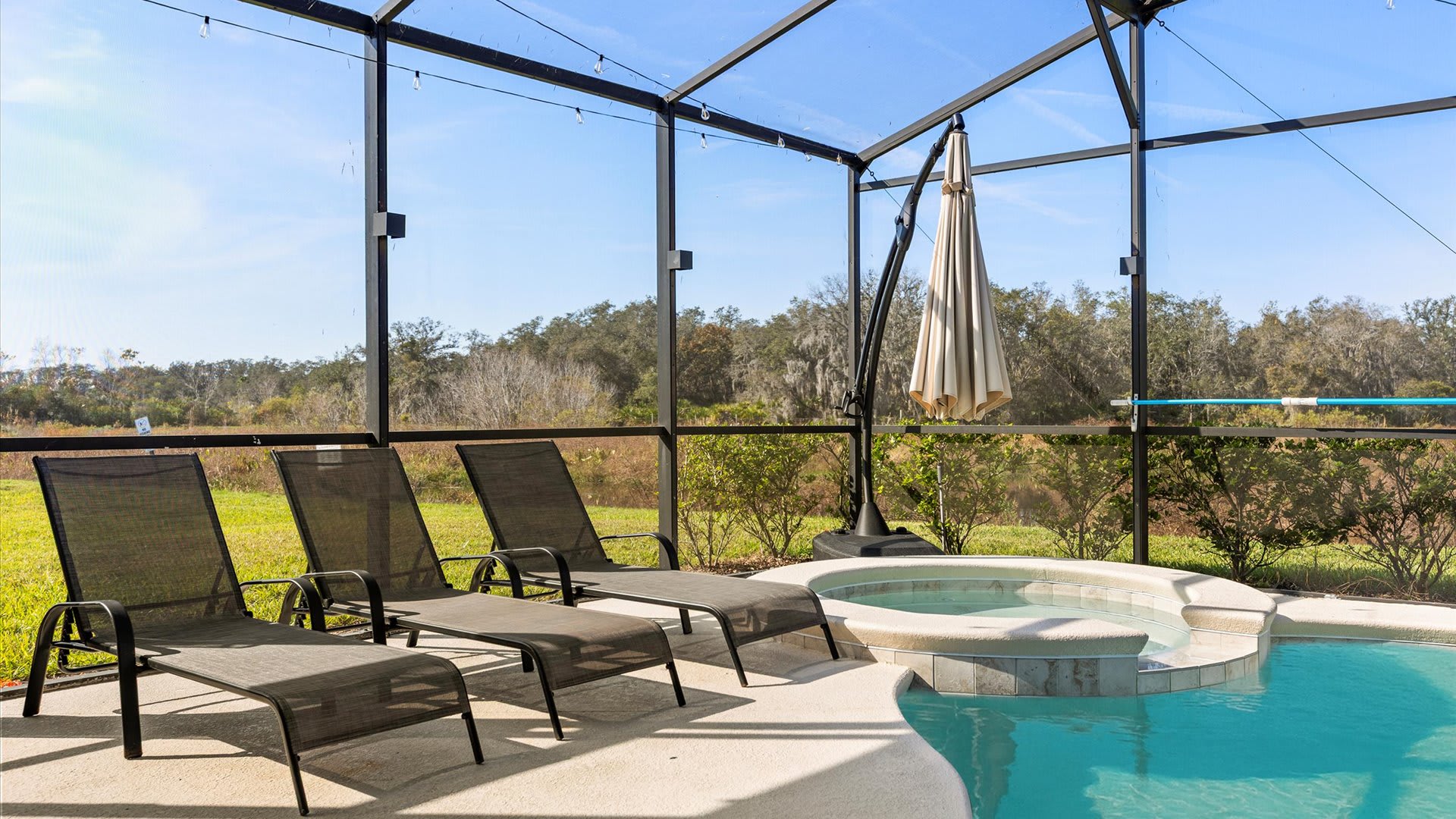 Sunny pool deck with loungers overlooking the water.