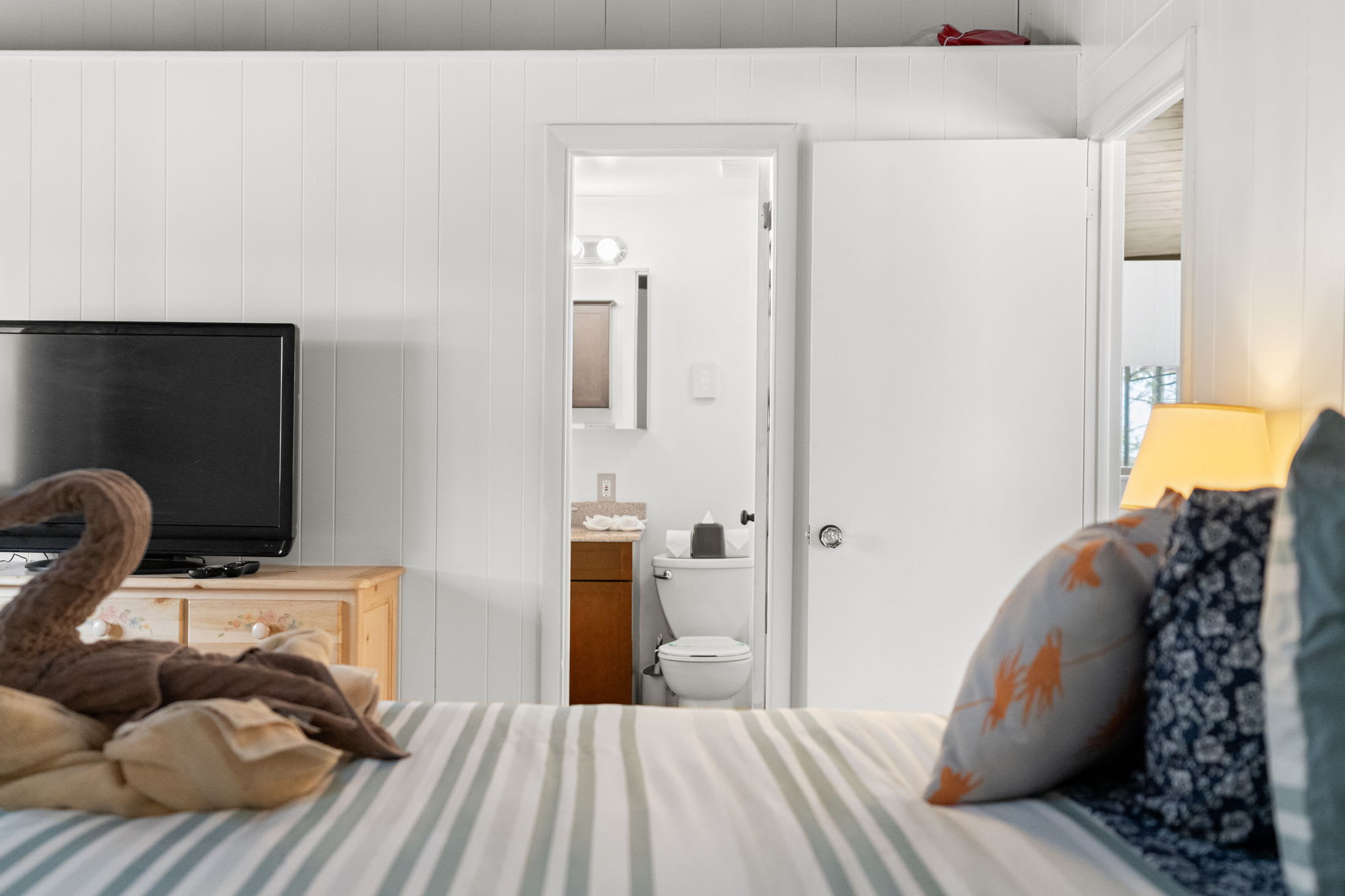 Nautical-themed bedroom with striped linens and cozy reading area in Pocono Mountains cabin