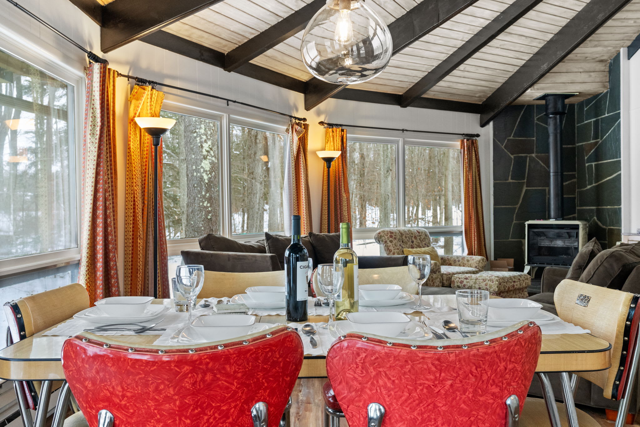 Bright dining nook with iconic red chairs and abundant natural light in Pocono cabin