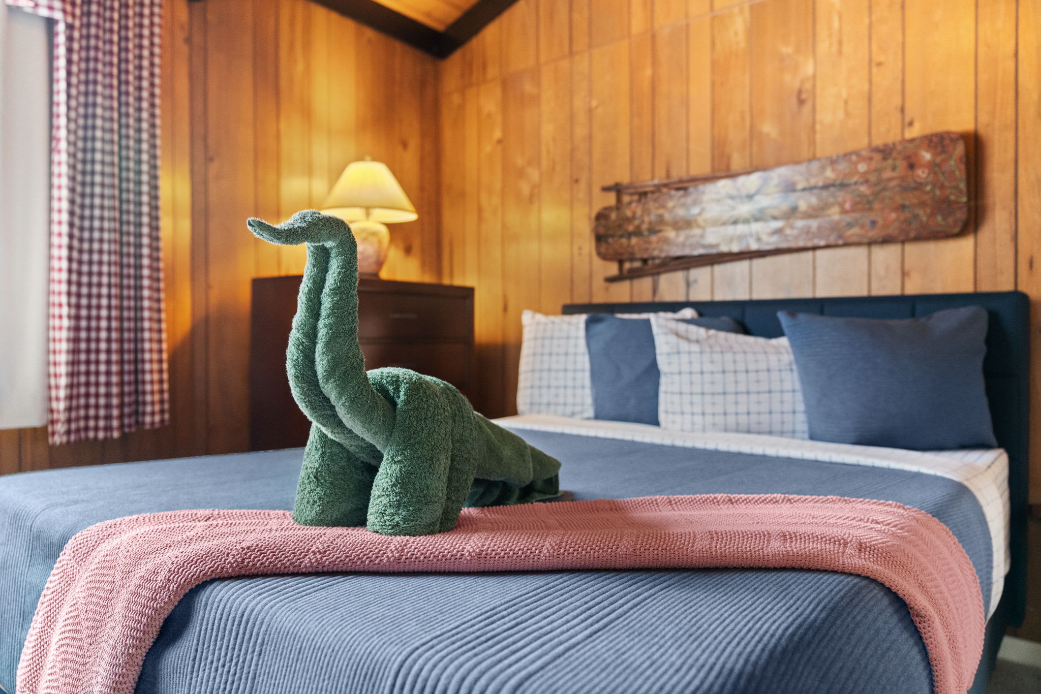 Cozy bedroom with vaulted ceiling and rustic wood beams in Lake Naomi cabin retreat