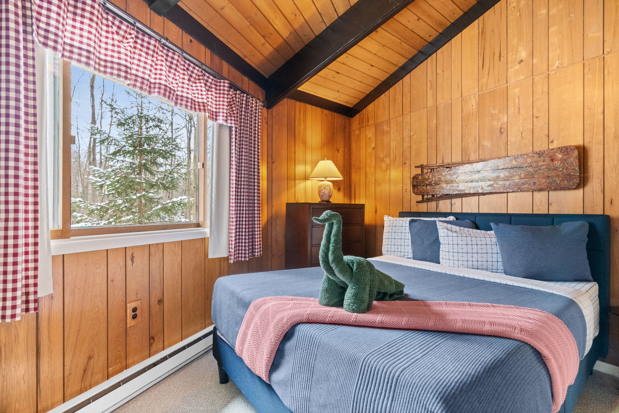 Bright bedroom with colorful bedding and A-frame architecture in Pocono vacation cabin