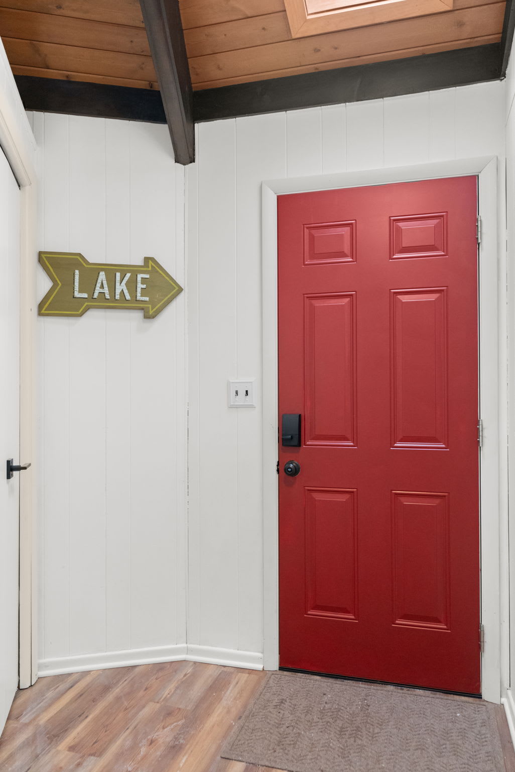 Charming cabin entrance with bright red door creating a warm welcome at Lake Naomi Pocono retreat