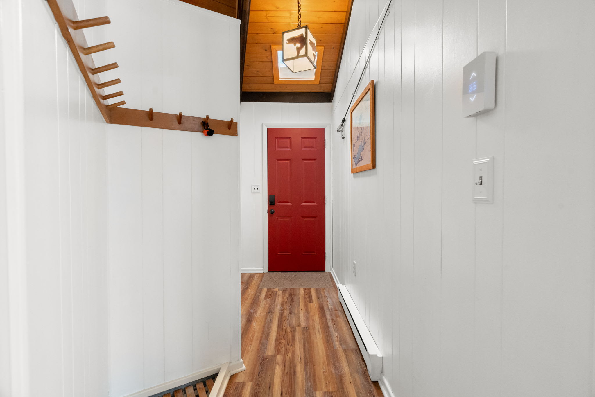 Welcoming cabin entryway with vibrant red door and rustic wood accents at Lake Naomi retreat