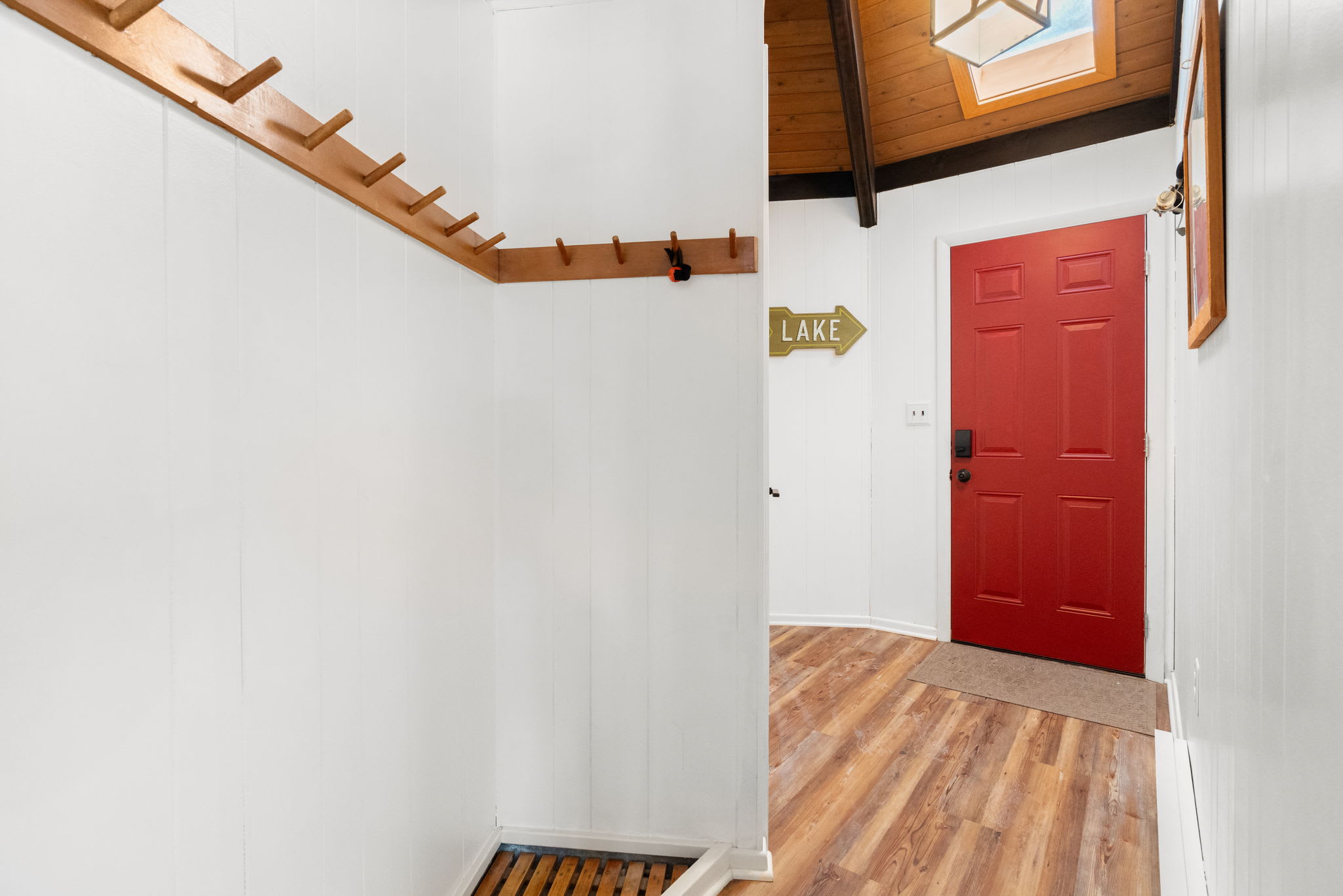 Warm hardwood floors leading to the charming red front door in Lake Naomi Pocono cabin
