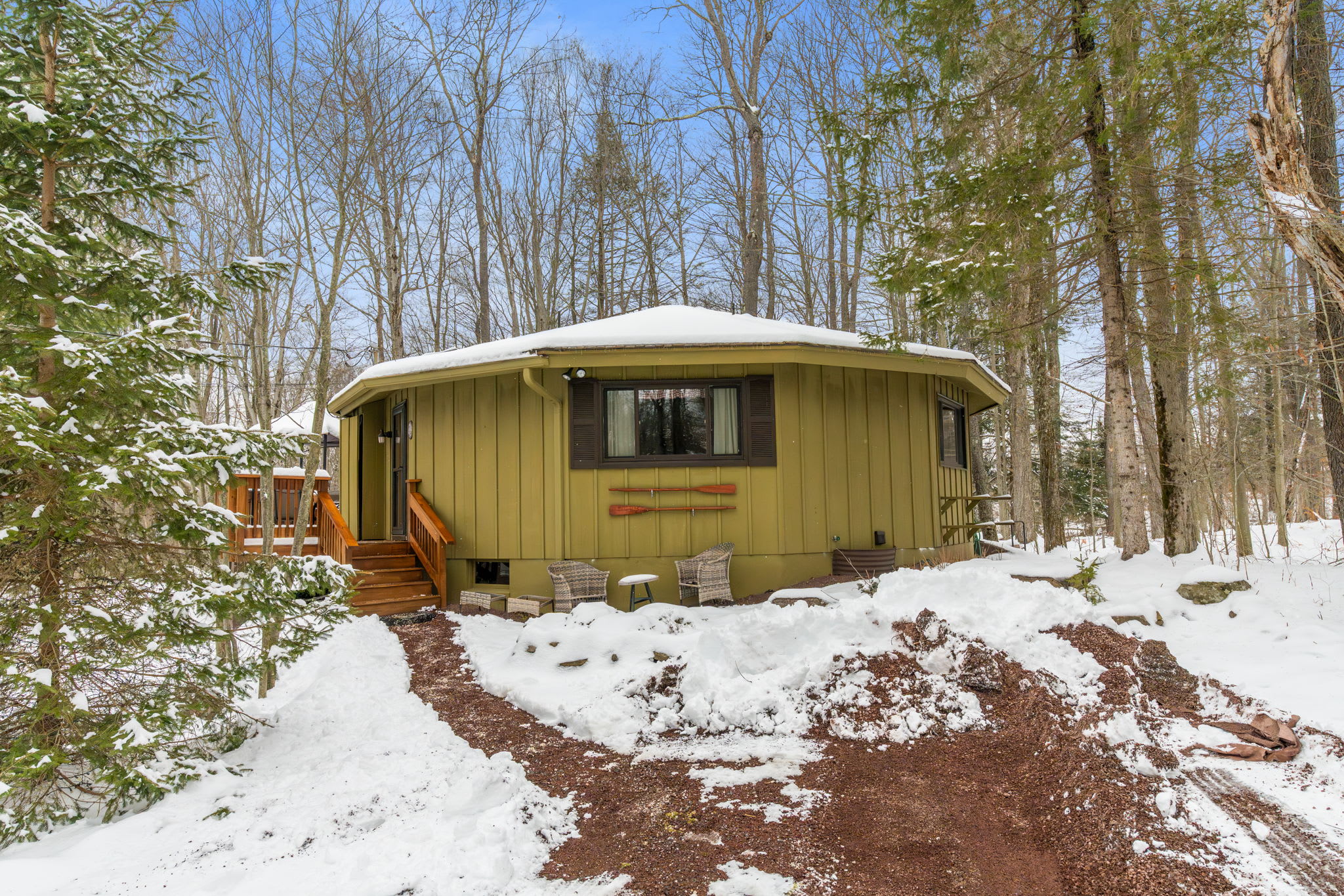 Charming red-door cabin entrance surrounded by pristine winter snow in Lake Naomi Pocono Mountains