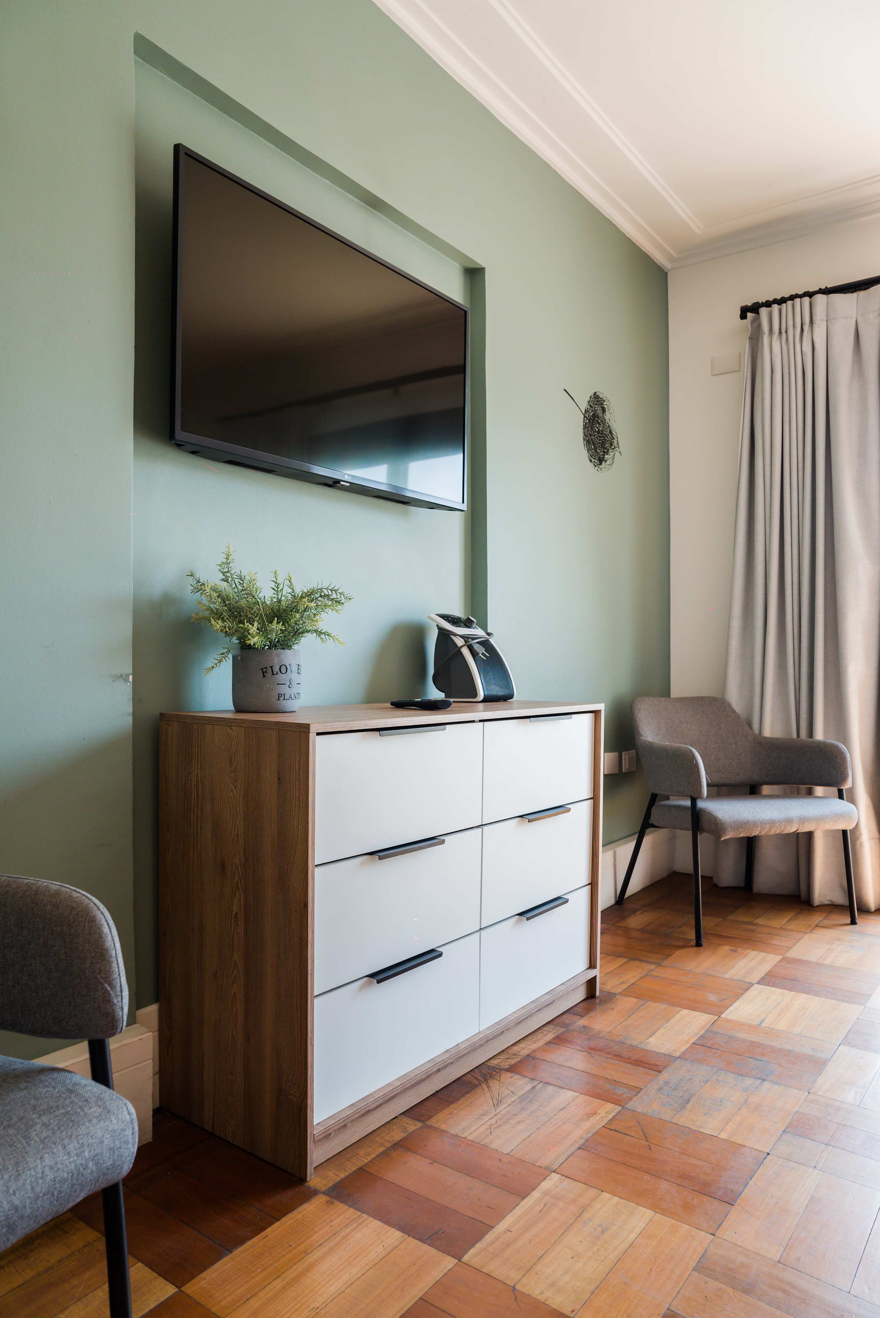 Relax in this cozy living space with a modern TV setup and stylish decor, perfect for unwinding after a day of exploring.