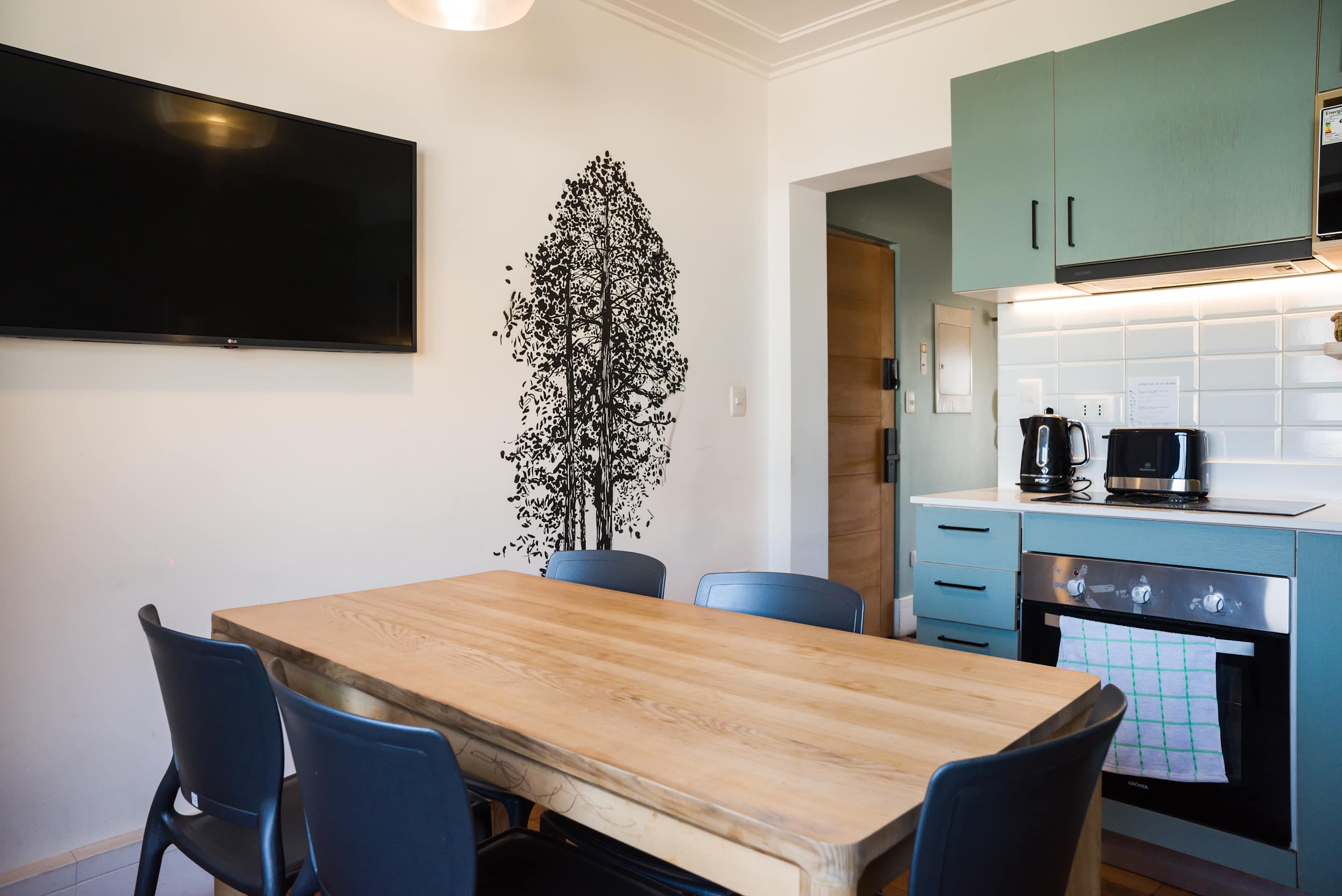 Cozy dining area with modern kitchen amenities and artistic wall decor, perfect for intimate meals.