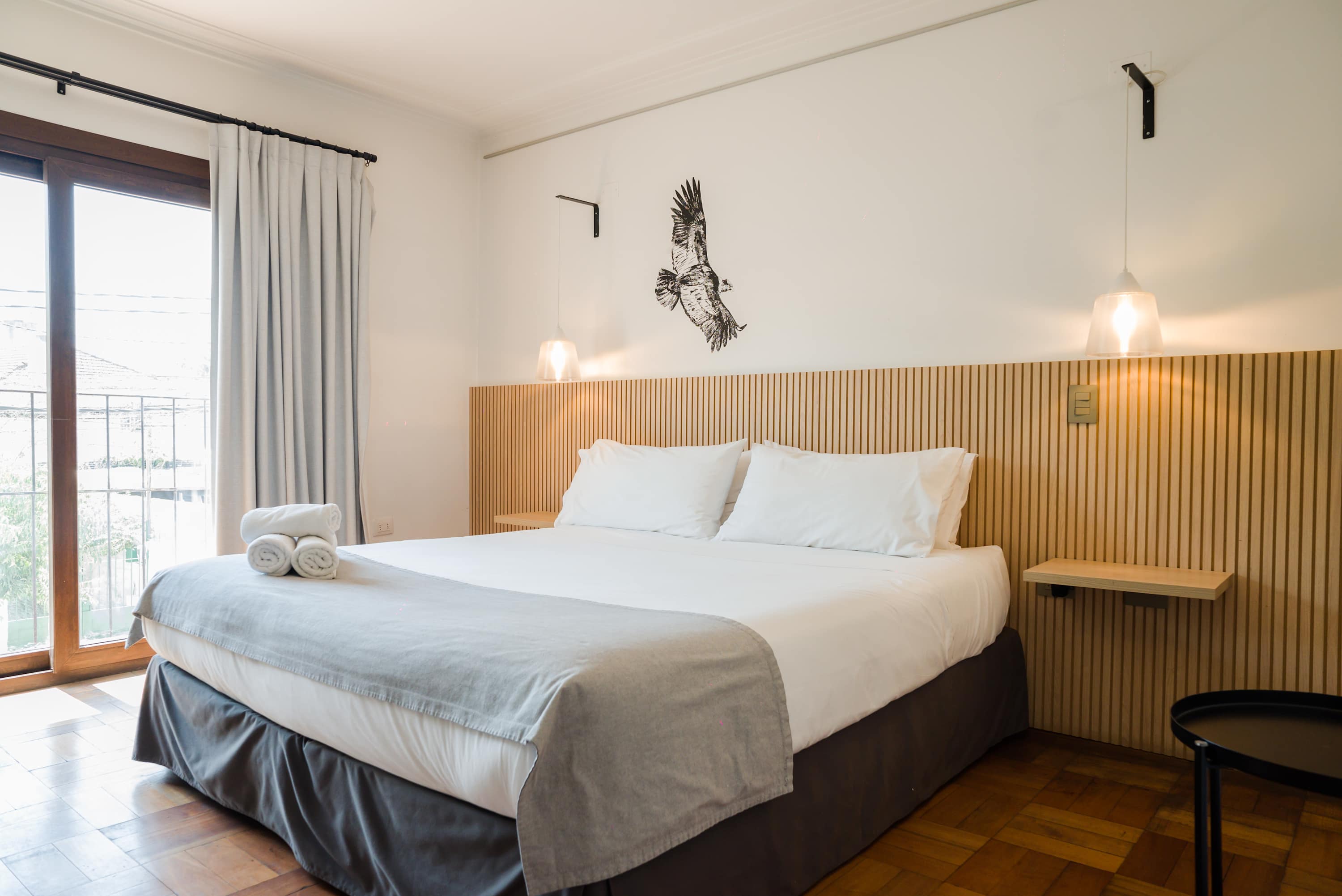 Relax in this cozy bedroom with modern decor and ample natural light, perfect for a restful stay.