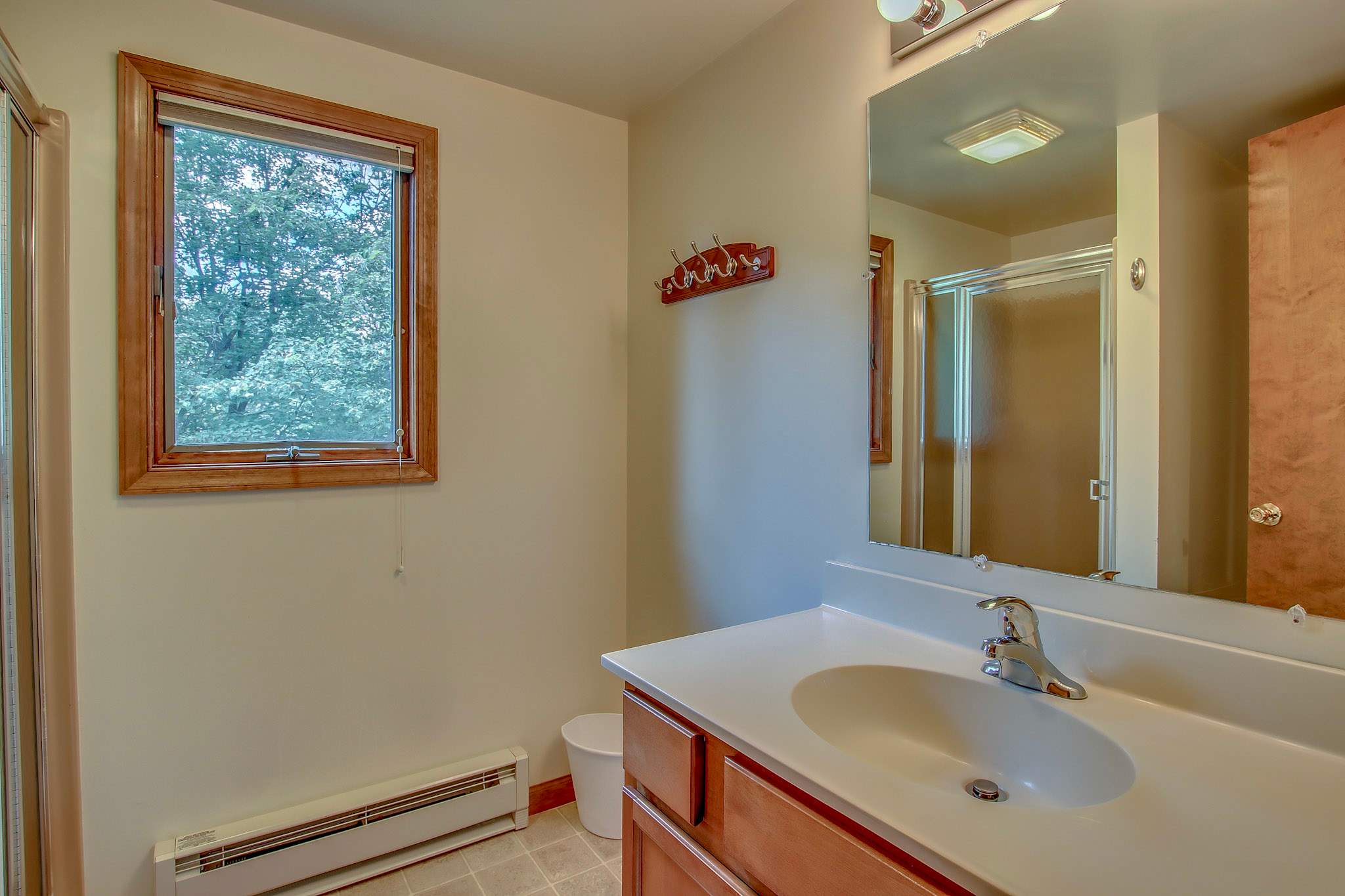 Bright upper-level bathroom with walk-in shower and natural light from the window