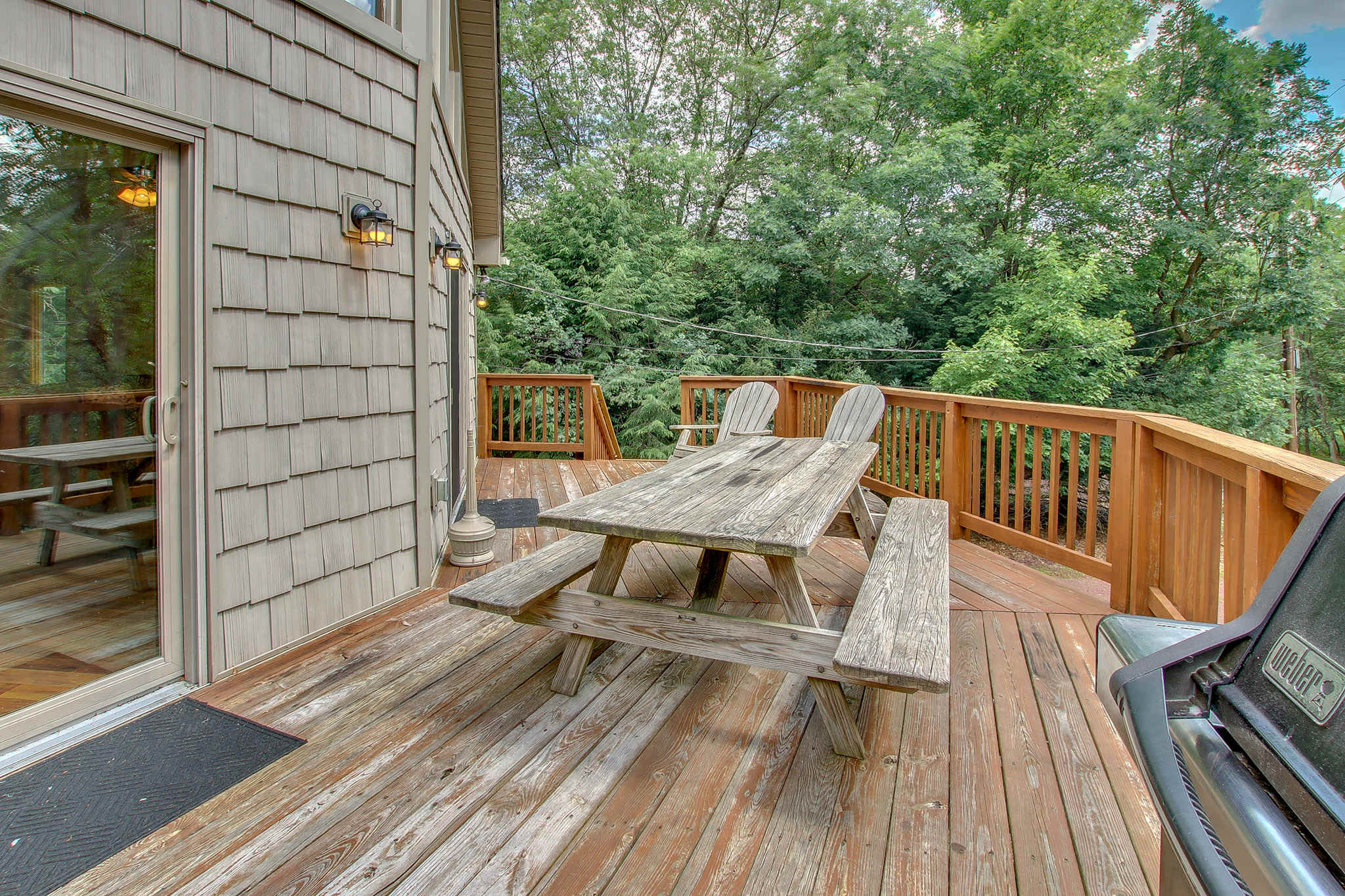 Share meals at the shaded deck table while surrounded by peaceful woodland