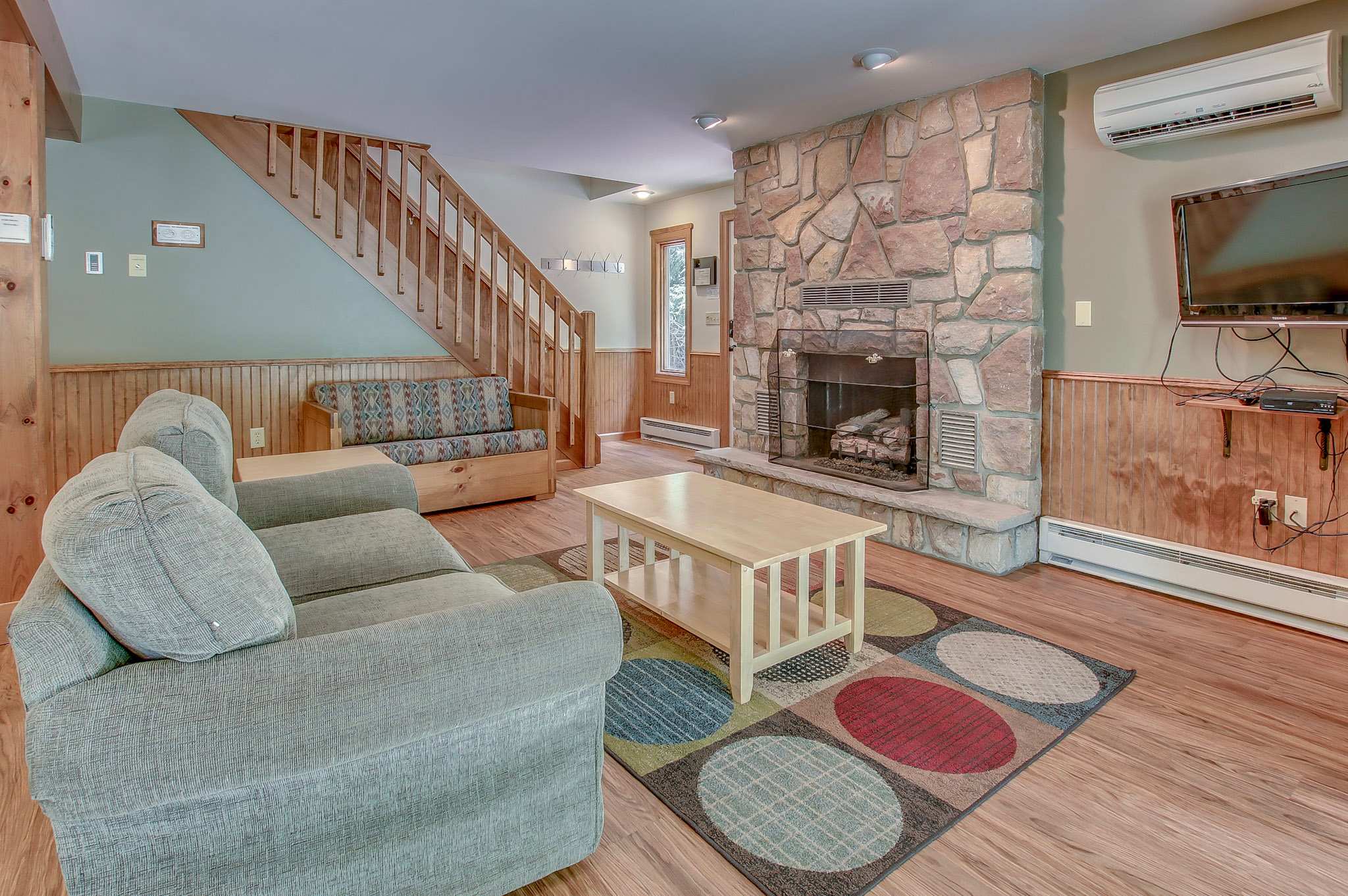 Relax in the bright living room with vaulted ceilings and a warming stone fireplace