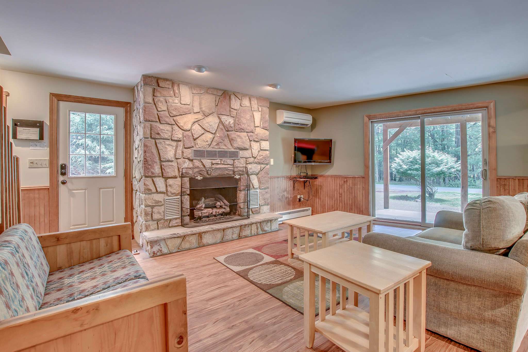 Gather with loved ones in the spacious living room with cozy stone fireplace