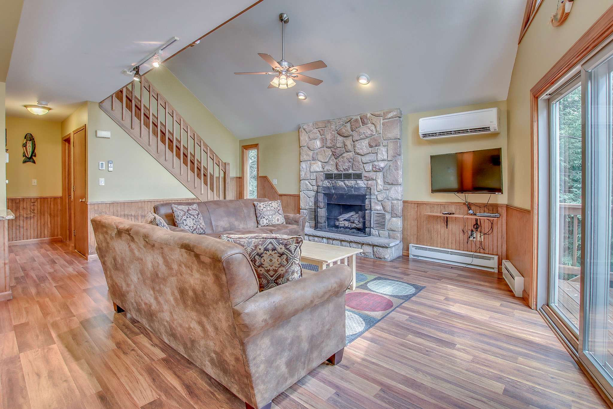Settle in on the plush sectional with views to the wooded deck through the glass doors