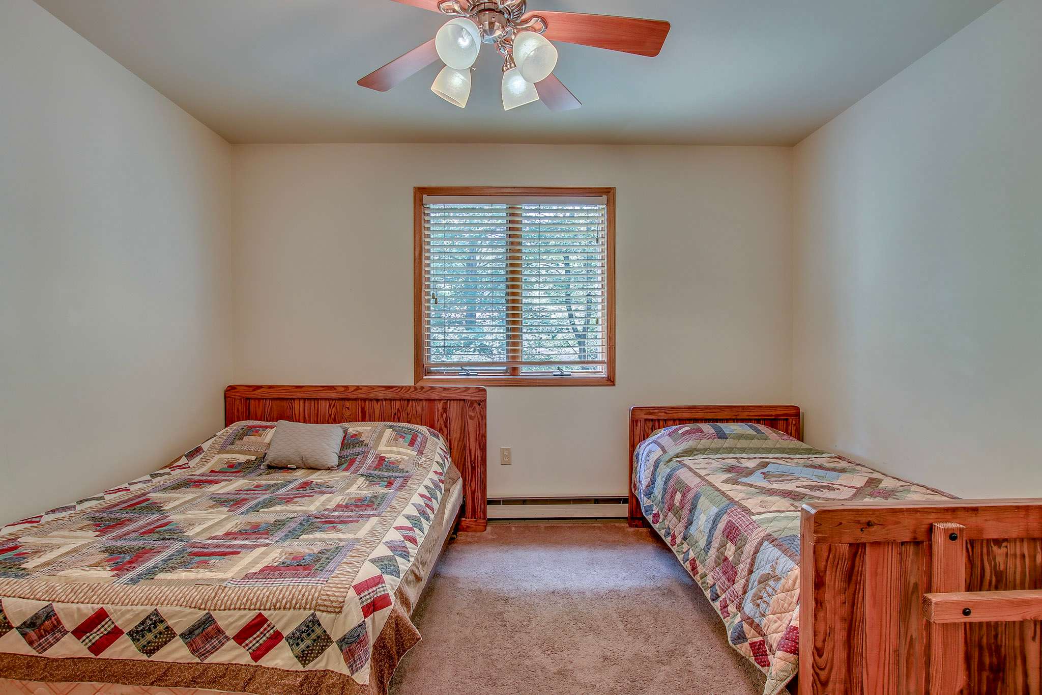 Spacious bedroom with dresser storage and natural light through the windows