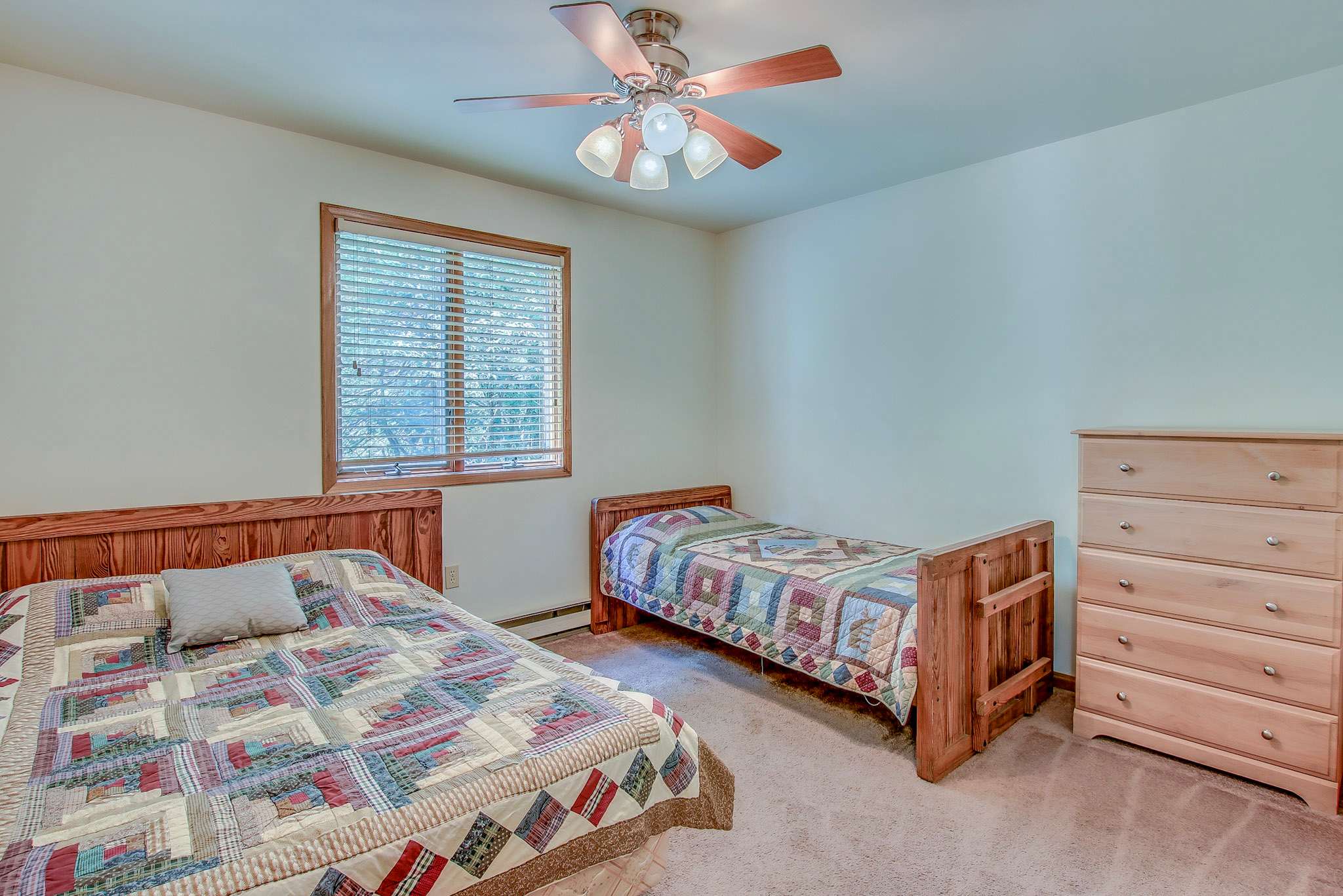 Comfortable twin beds with cozy quilts in this bright, cheerful bedroom