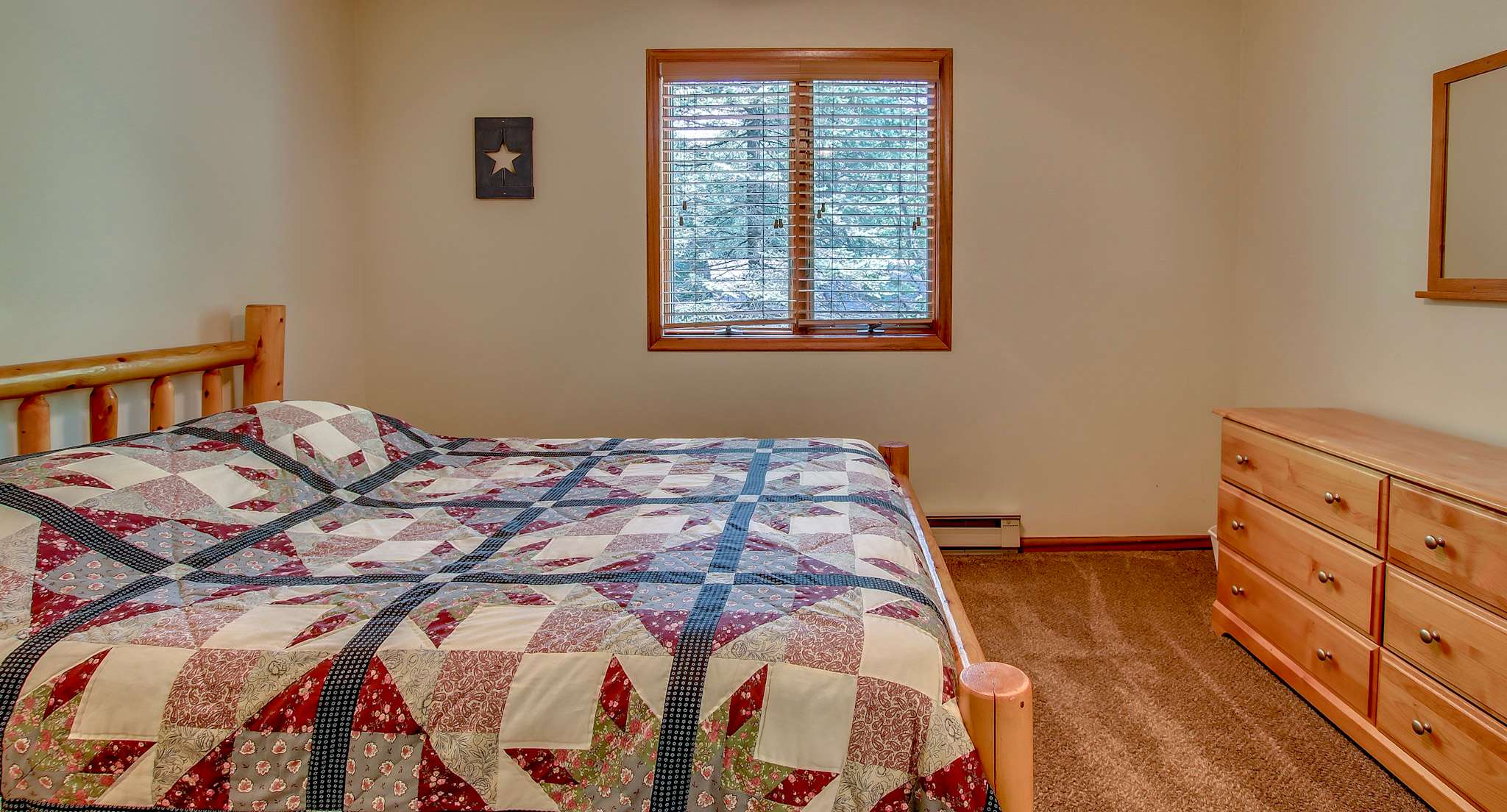 Charming log bed frame adds rustic character to this cozy bedroom retreat