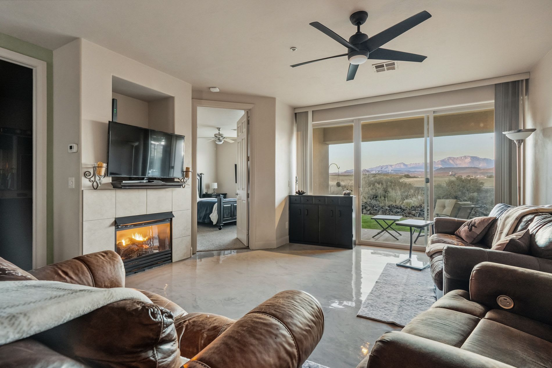 Spacious living room with fireplace, plush seating, and gorgeous red rock views.