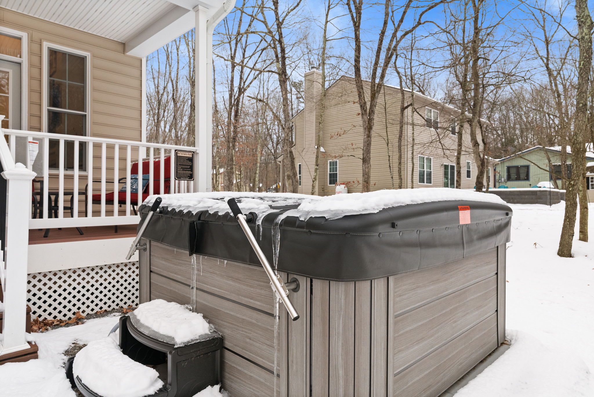 Backyard view of Poconos cabin with hot tub on deck - nestled among trees for ultimate privacy