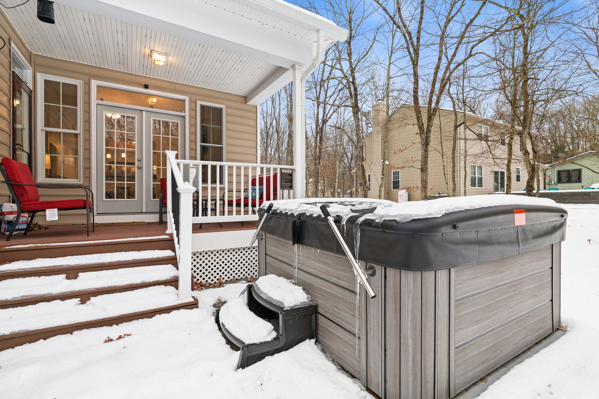 Private outdoor hot tub on covered deck with scenic woodland views - relax year-round at this Poconos getaway
