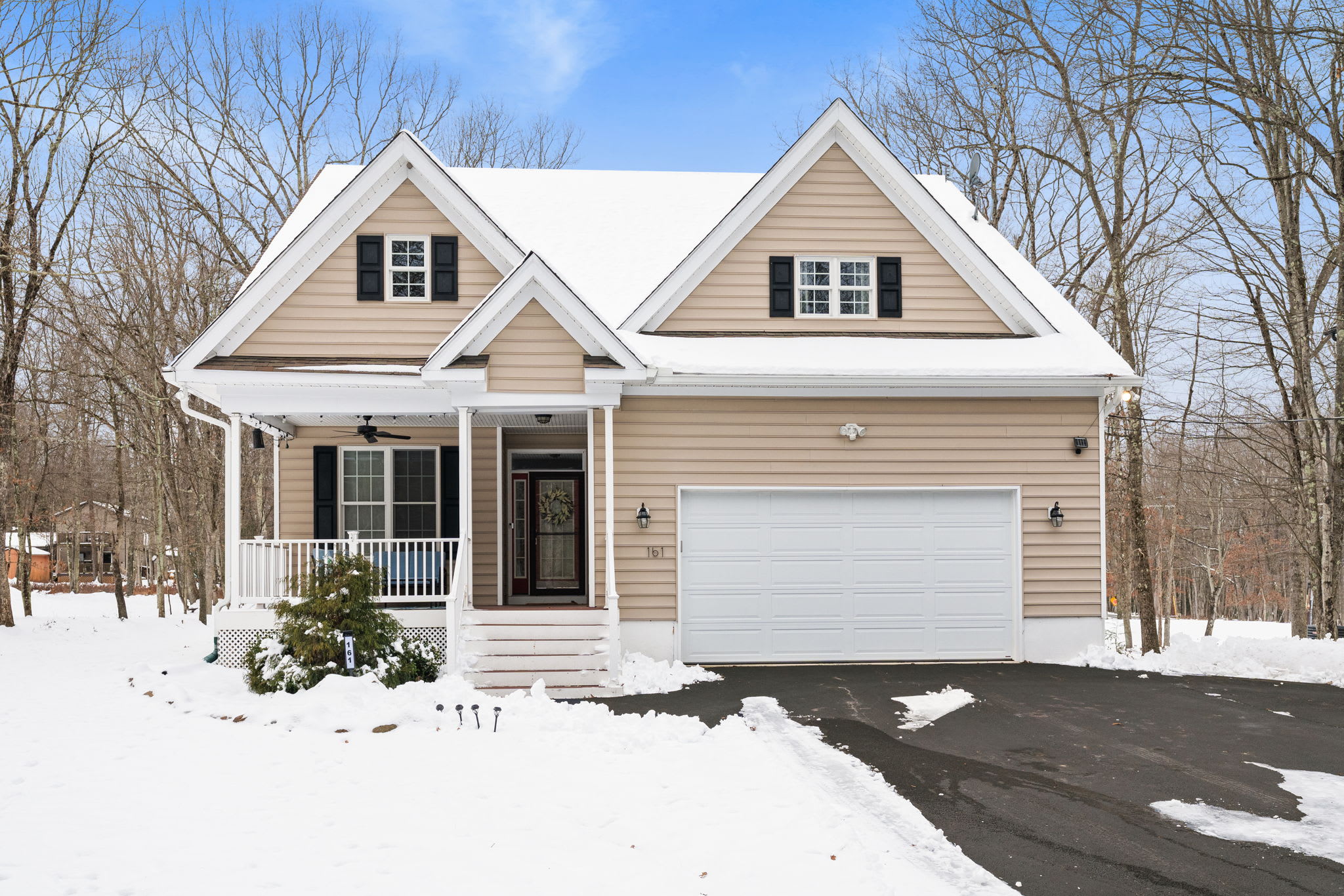 Welcoming front entrance of Poconos vacation home with 2-car garage and spacious driveway for guest parking
