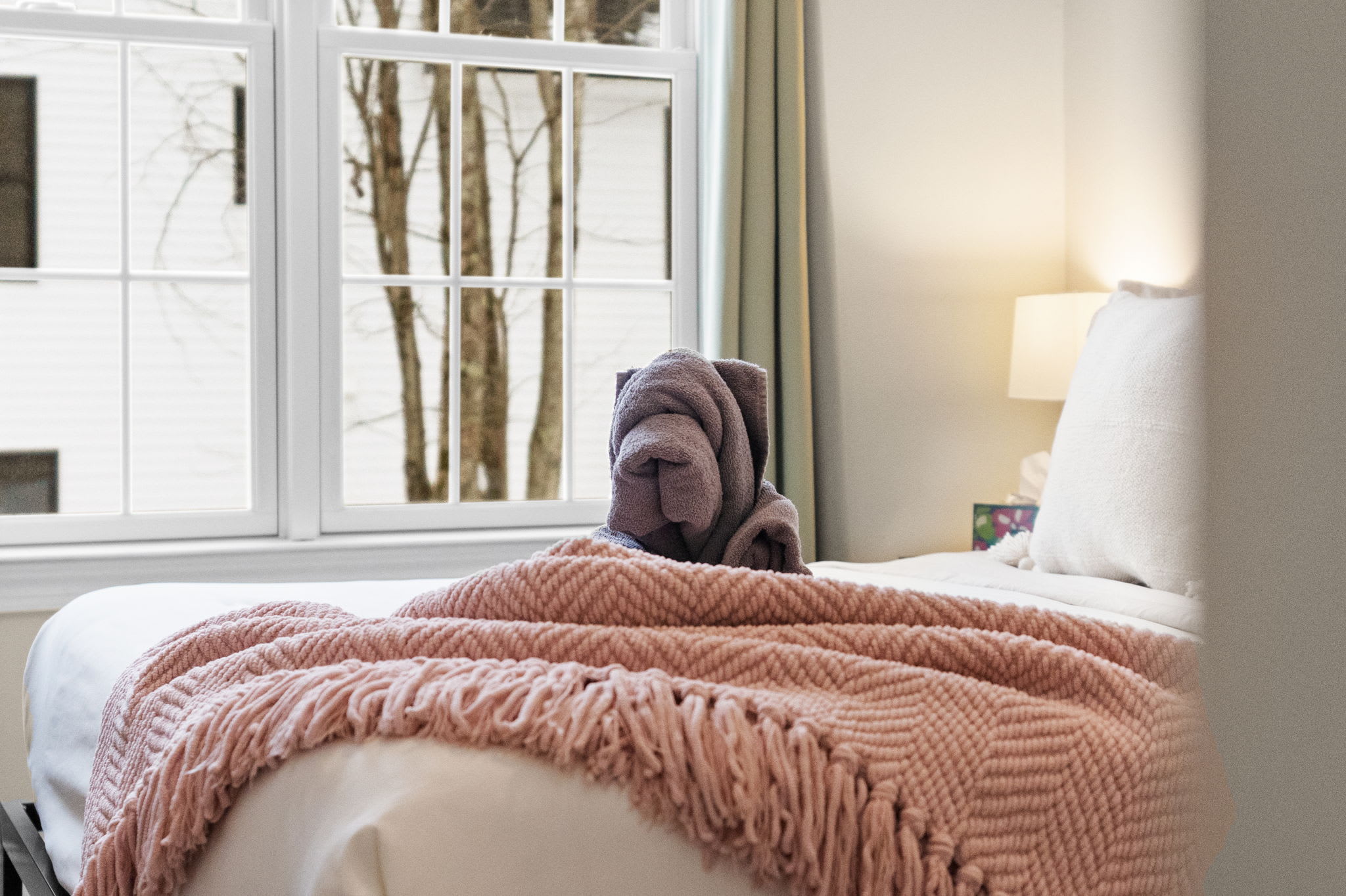 Beautifully decorated third bedroom with comfortable queen bed and cozy throw blanket