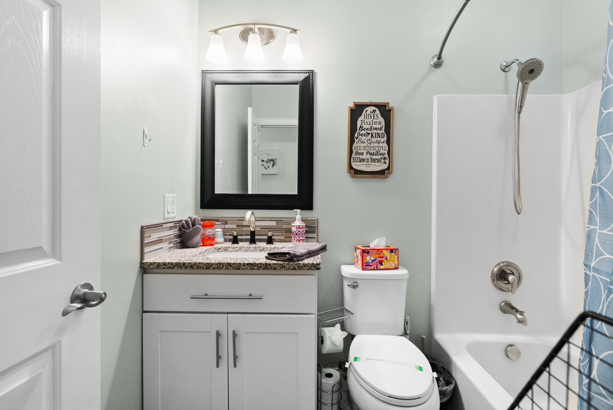 Spacious primary bathroom with double vanity, elegant mirror and modern finishes