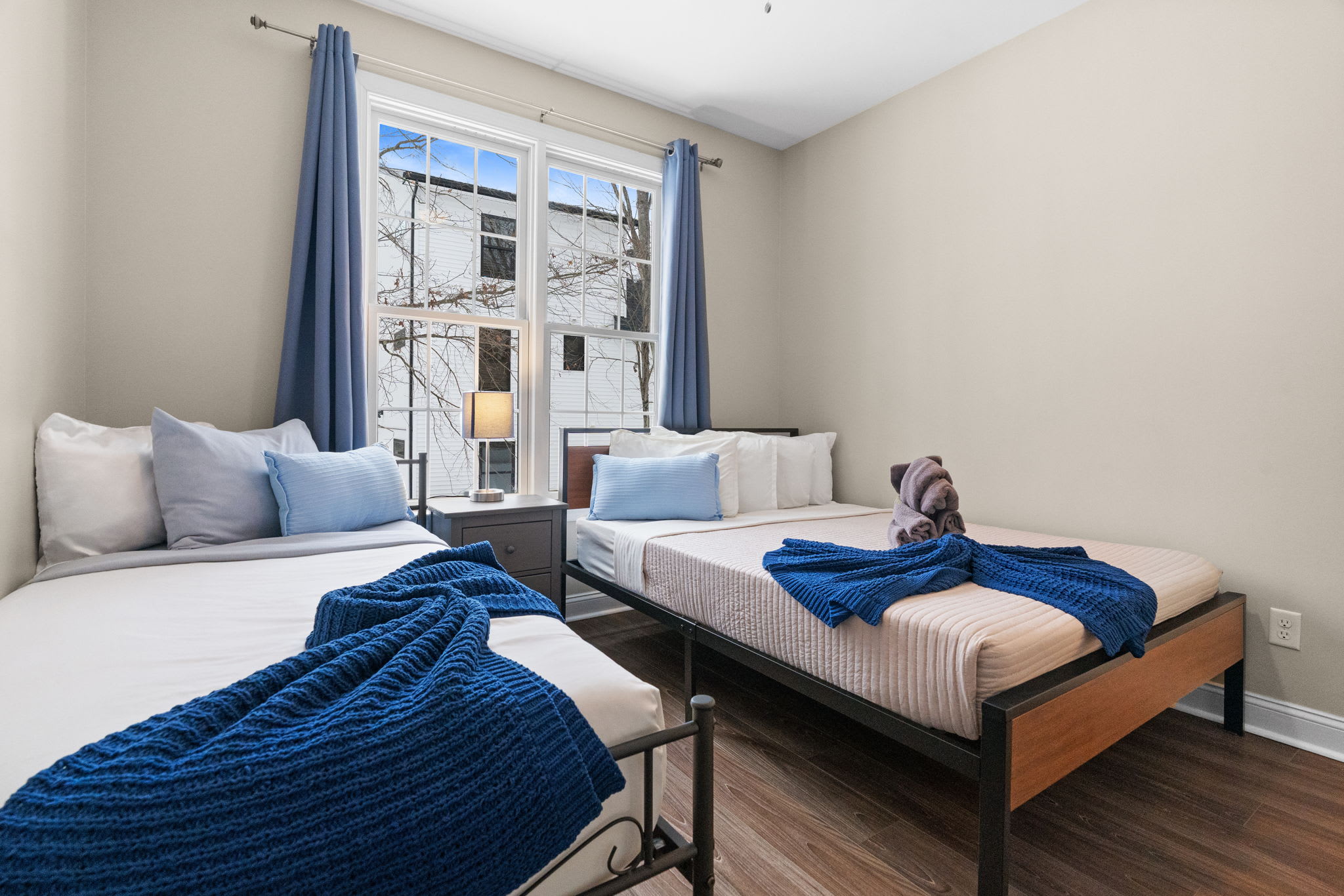 Restful second bedroom featuring comfortable queen bed with quality linens and calming decor