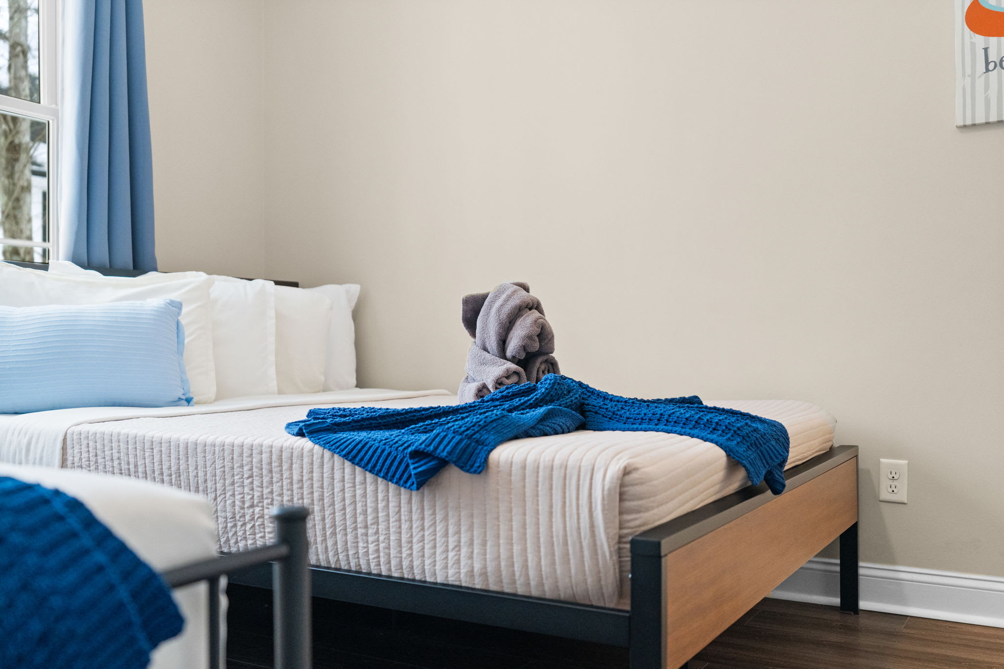 Bright second bedroom with blue accents and natural light streaming through windows
