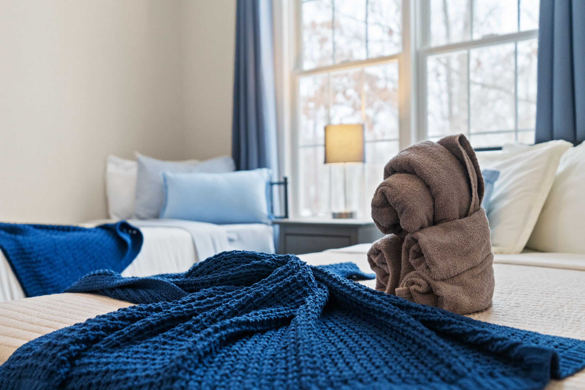 Inviting second bedroom queen bed with soft blue comforter and throw blanket for cozy nights