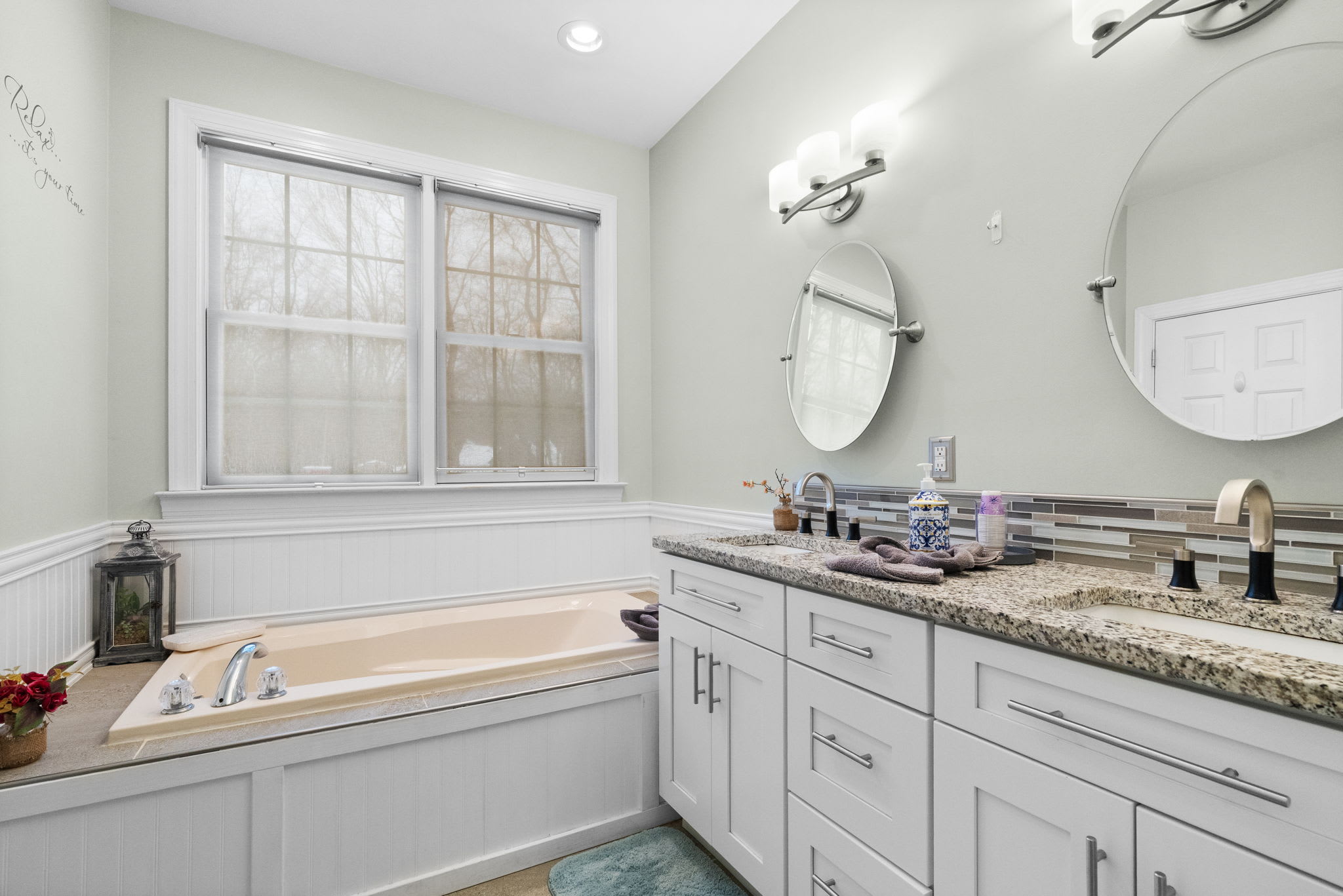 Clean second bathroom with tub/shower combo, white subway tile and classic fixtures