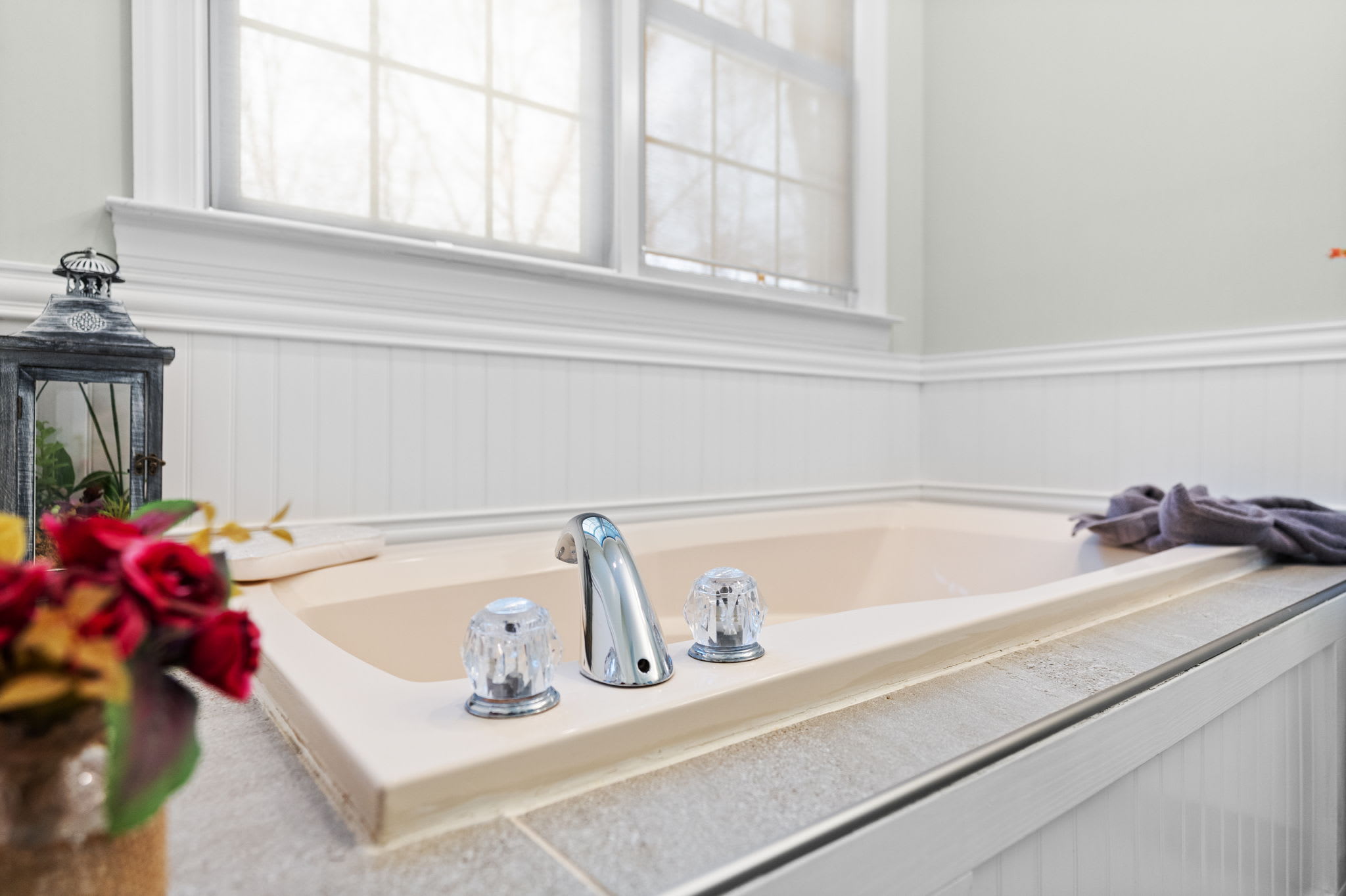 Relaxing second bathroom with soaking tub, fresh flowers and warm spa-like ambiance