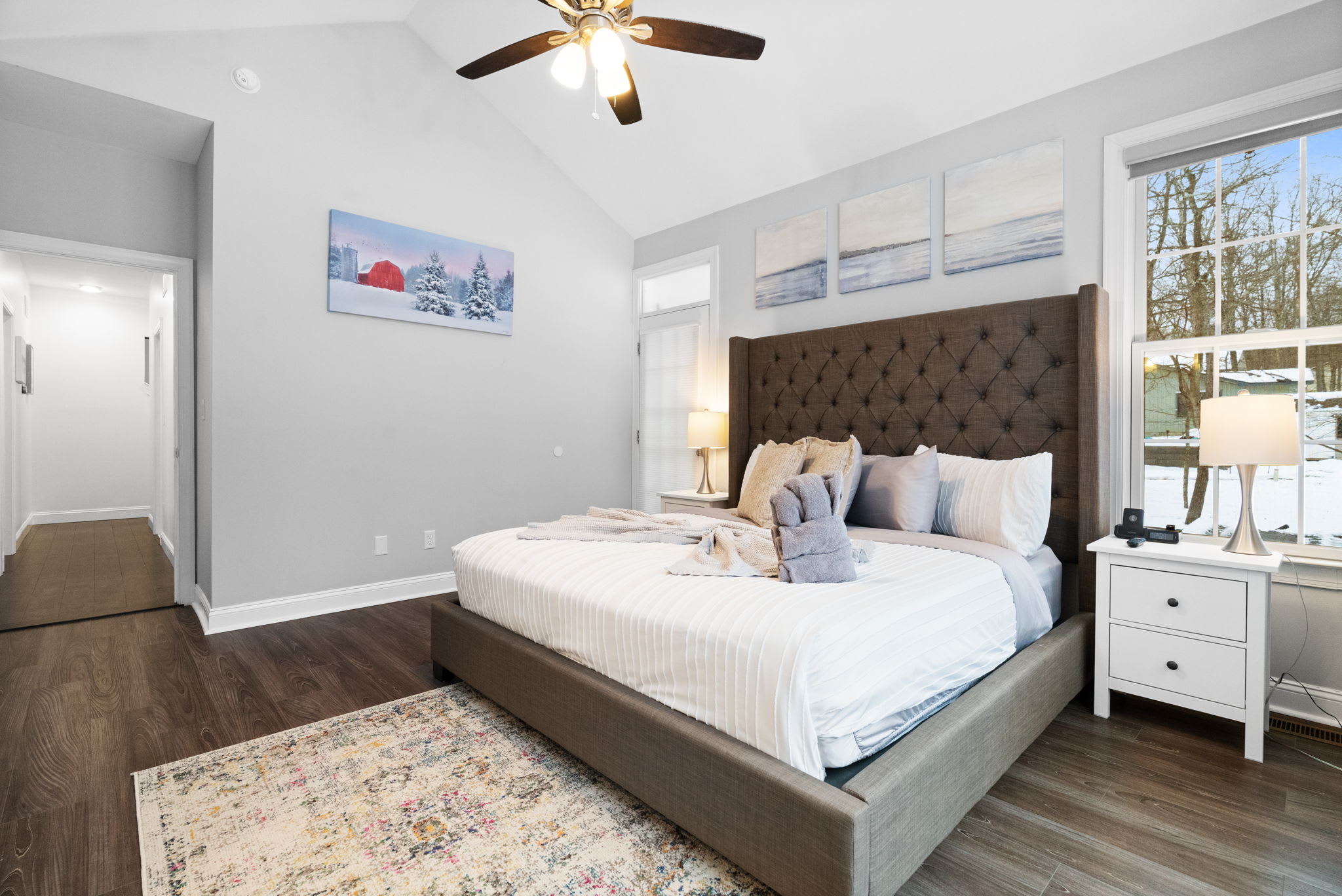 Serene master bedroom with premium king bed, white linens and warm wood floors in Poconos cabin