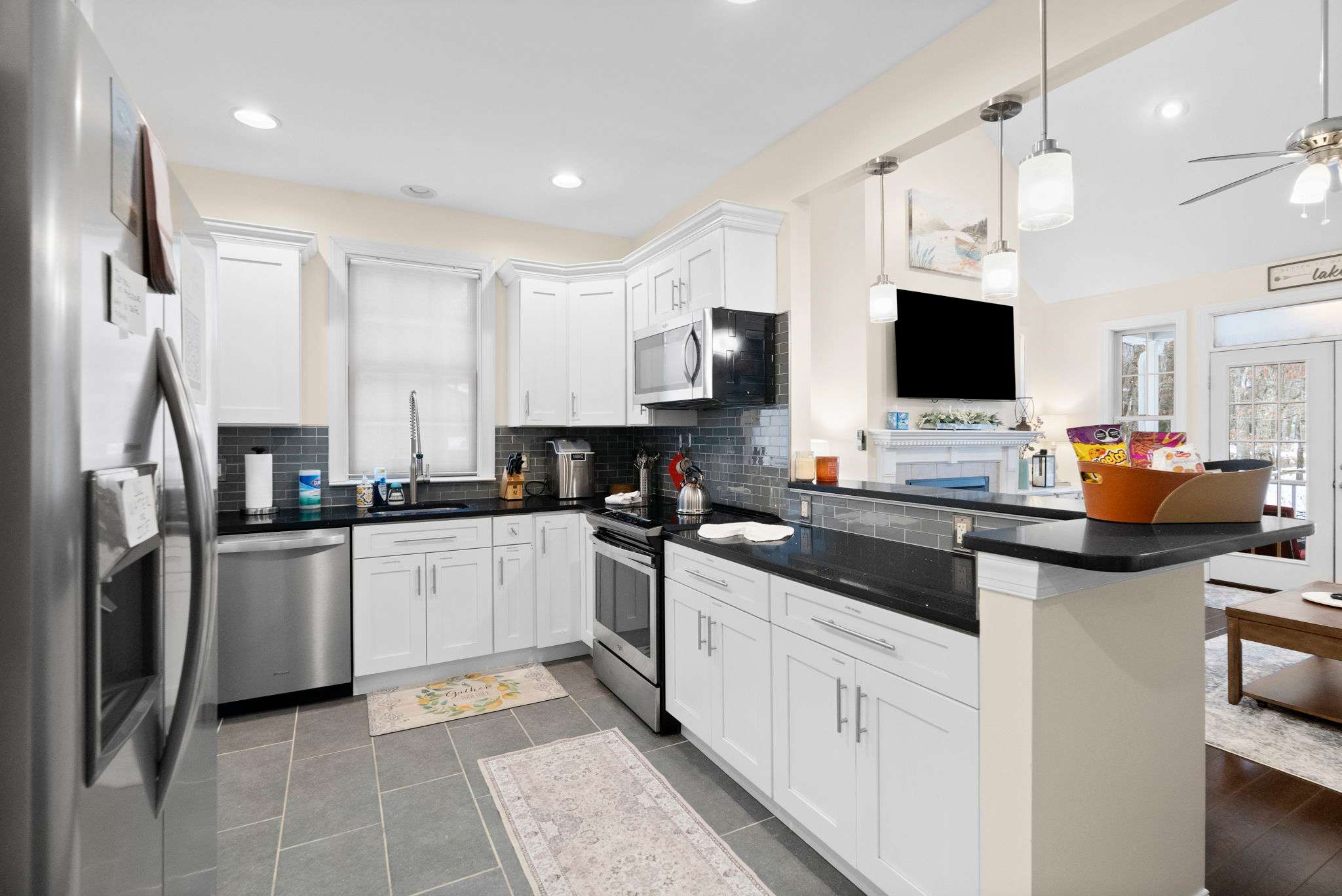 Fully-equipped gourmet kitchen with modern appliances, island seating and stunning natural light