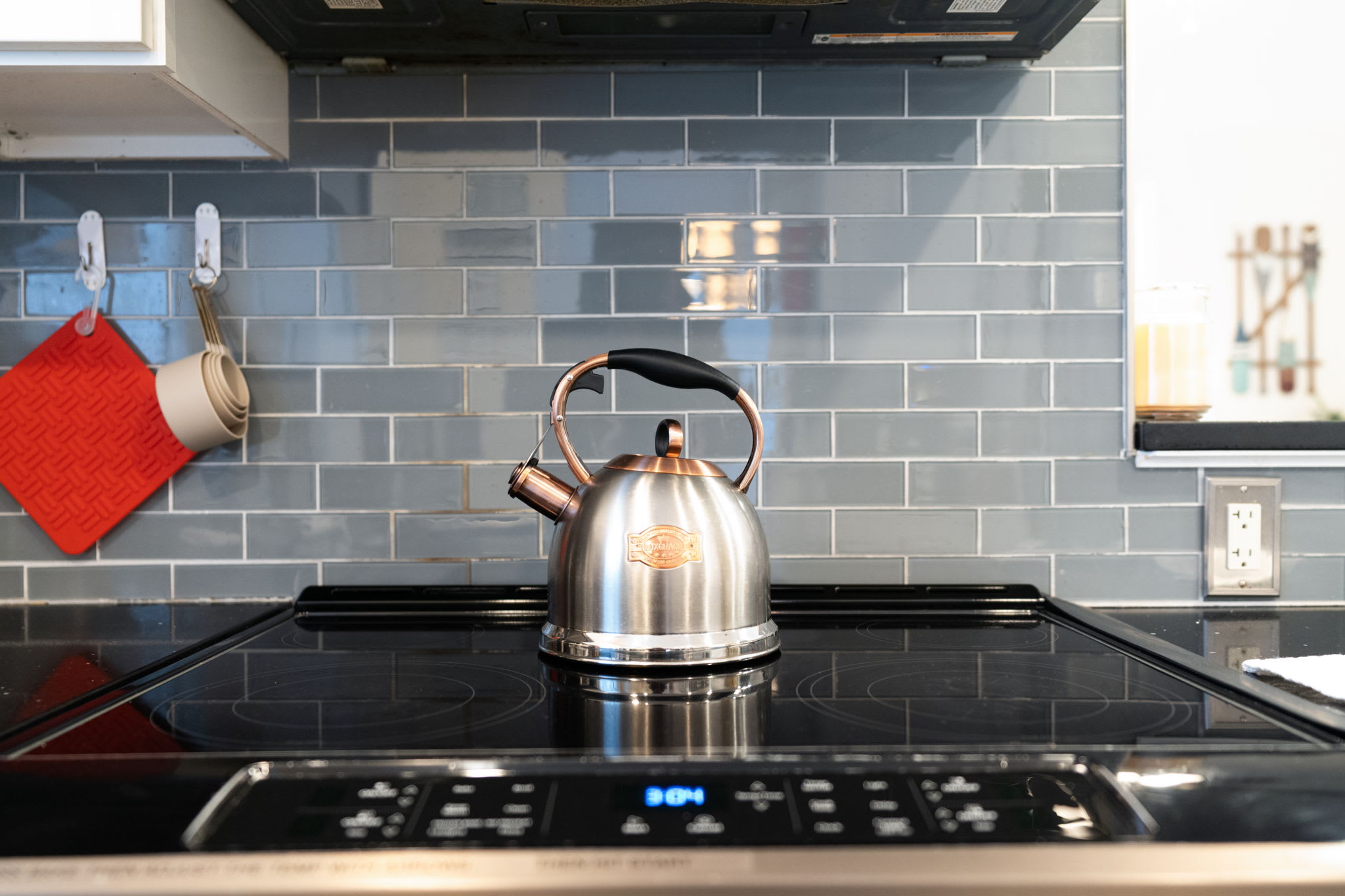 Kitchen cooking area with electric stovetop and stylish backsplash - all the tools for gourmet cooking