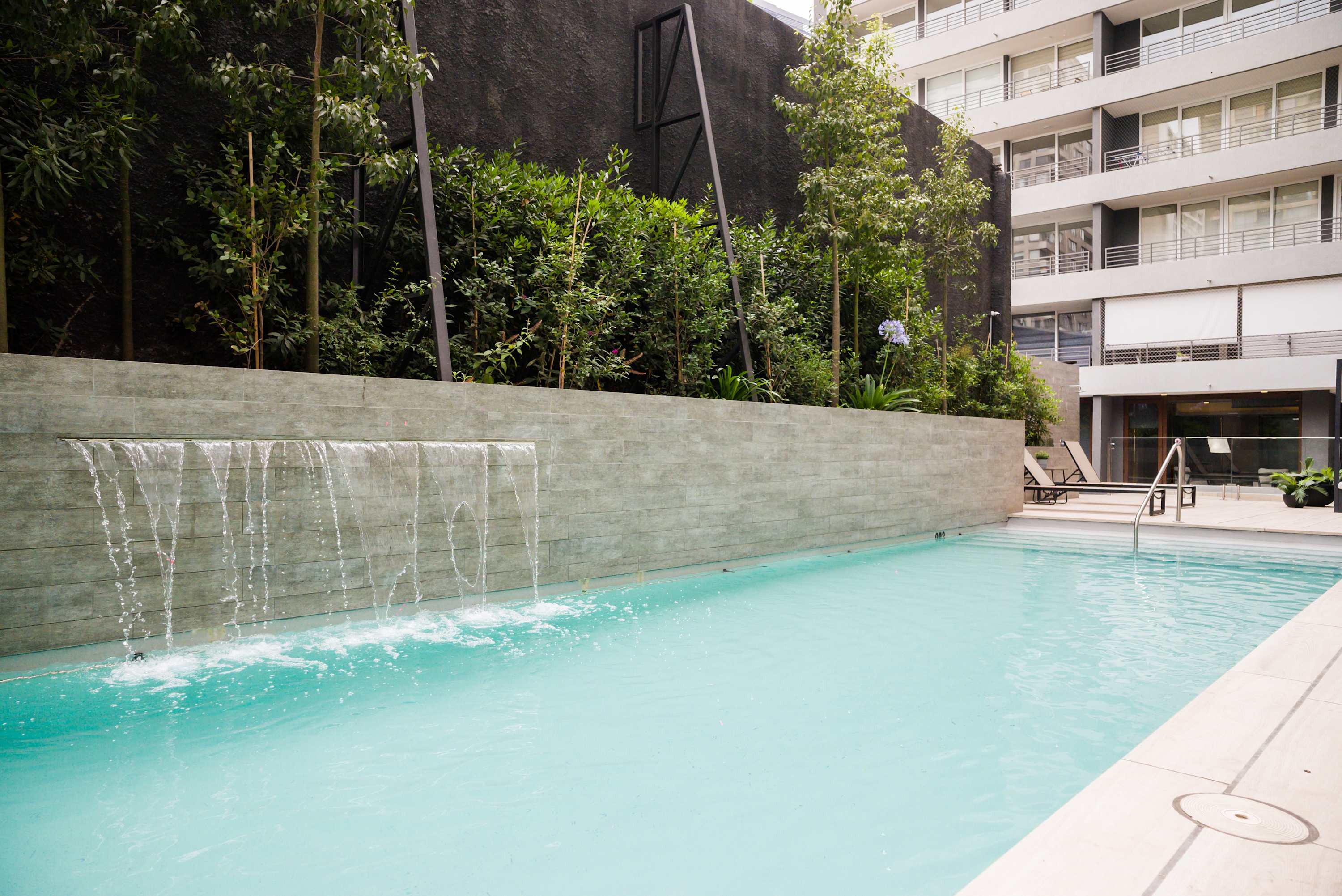 Relax by the serene pool with a soothing waterfall, perfect for unwinding after a day of exploring. (Common Area)