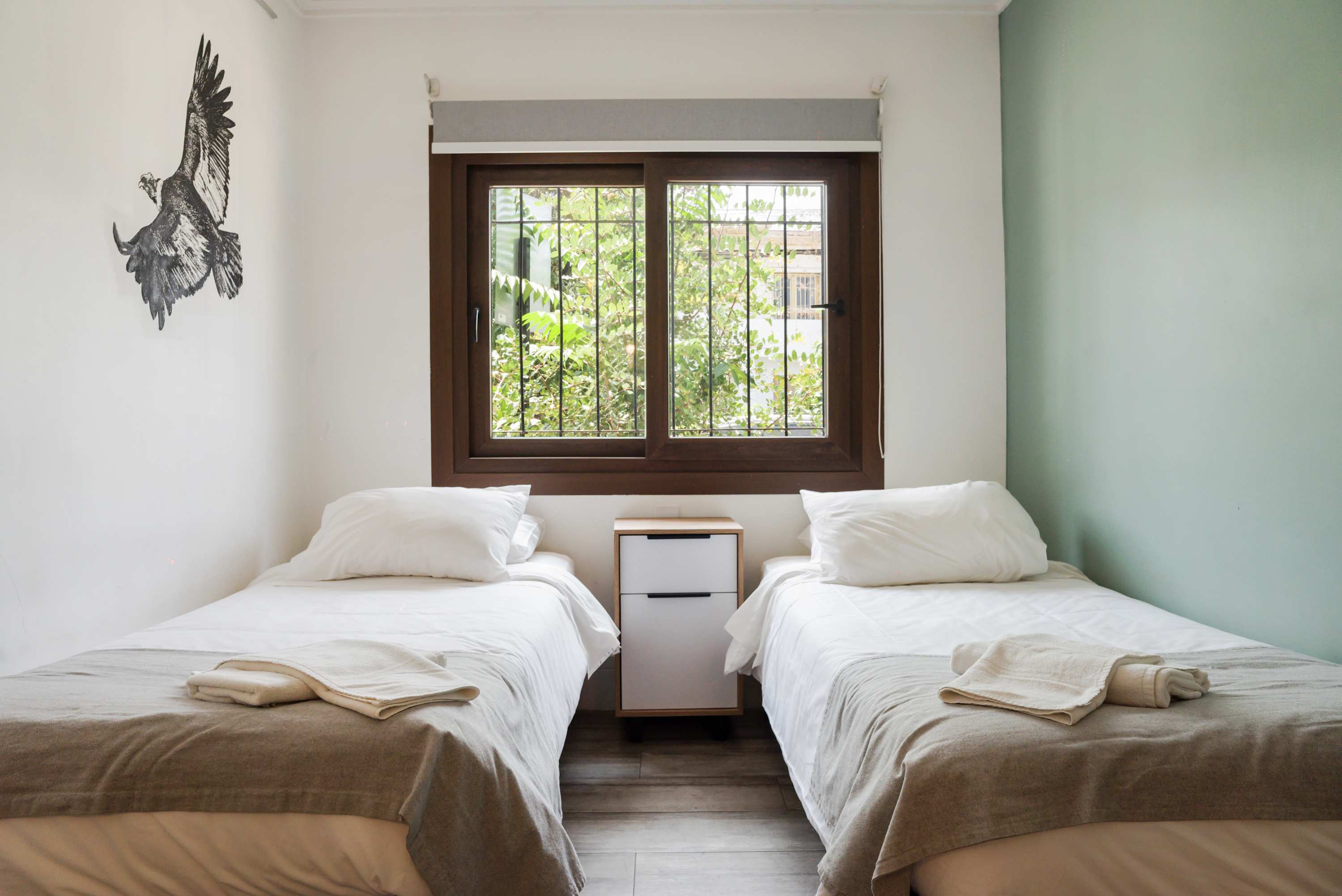 Cozy bedroom with twin beds and a serene garden view, perfect for a restful stay.