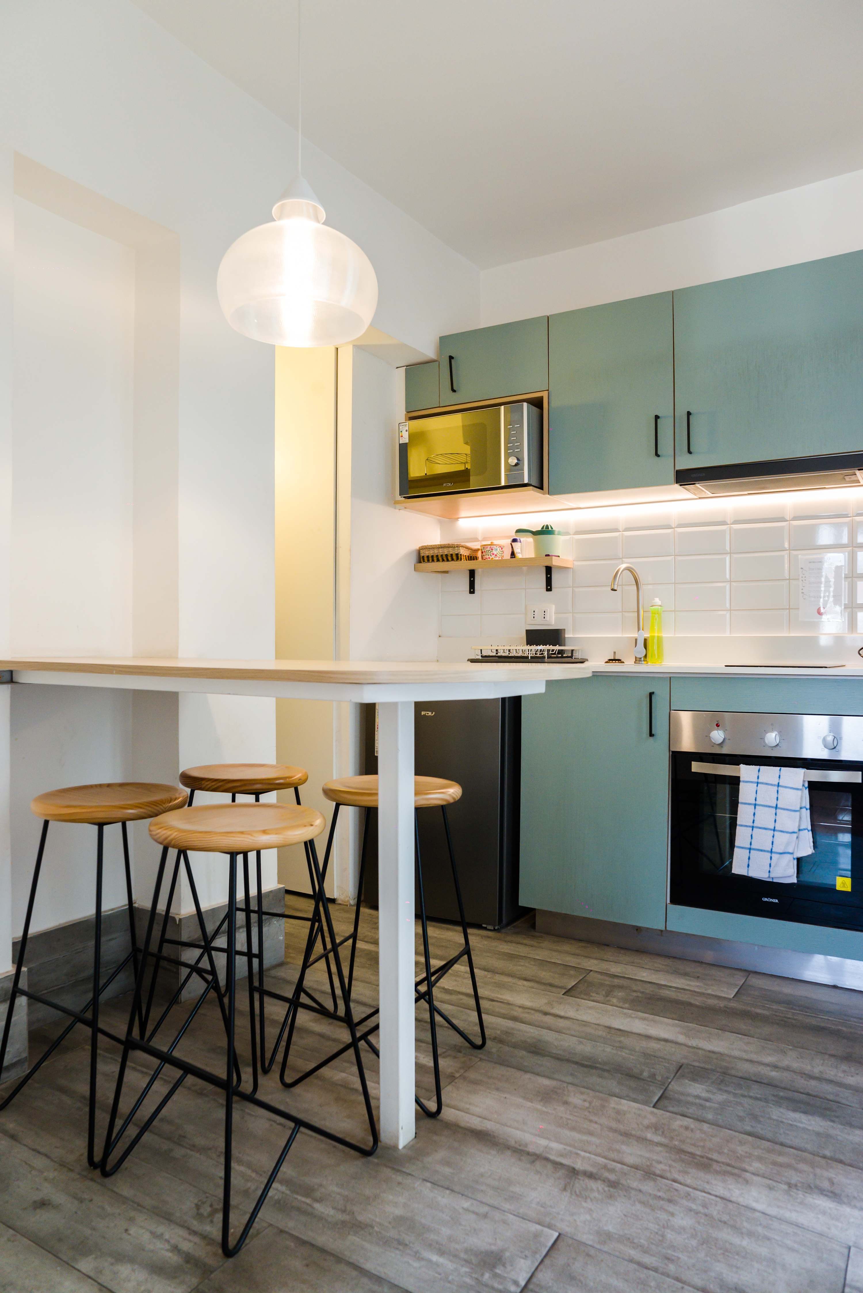 Chic and functional kitchen with modern appliances and stylish seating, perfect for cozy meals.