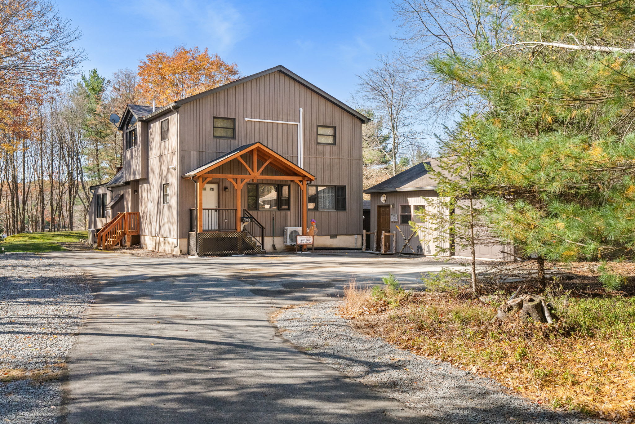 Charming A-frame chalet exterior with spacious driveway parking and secluded forest surroundings