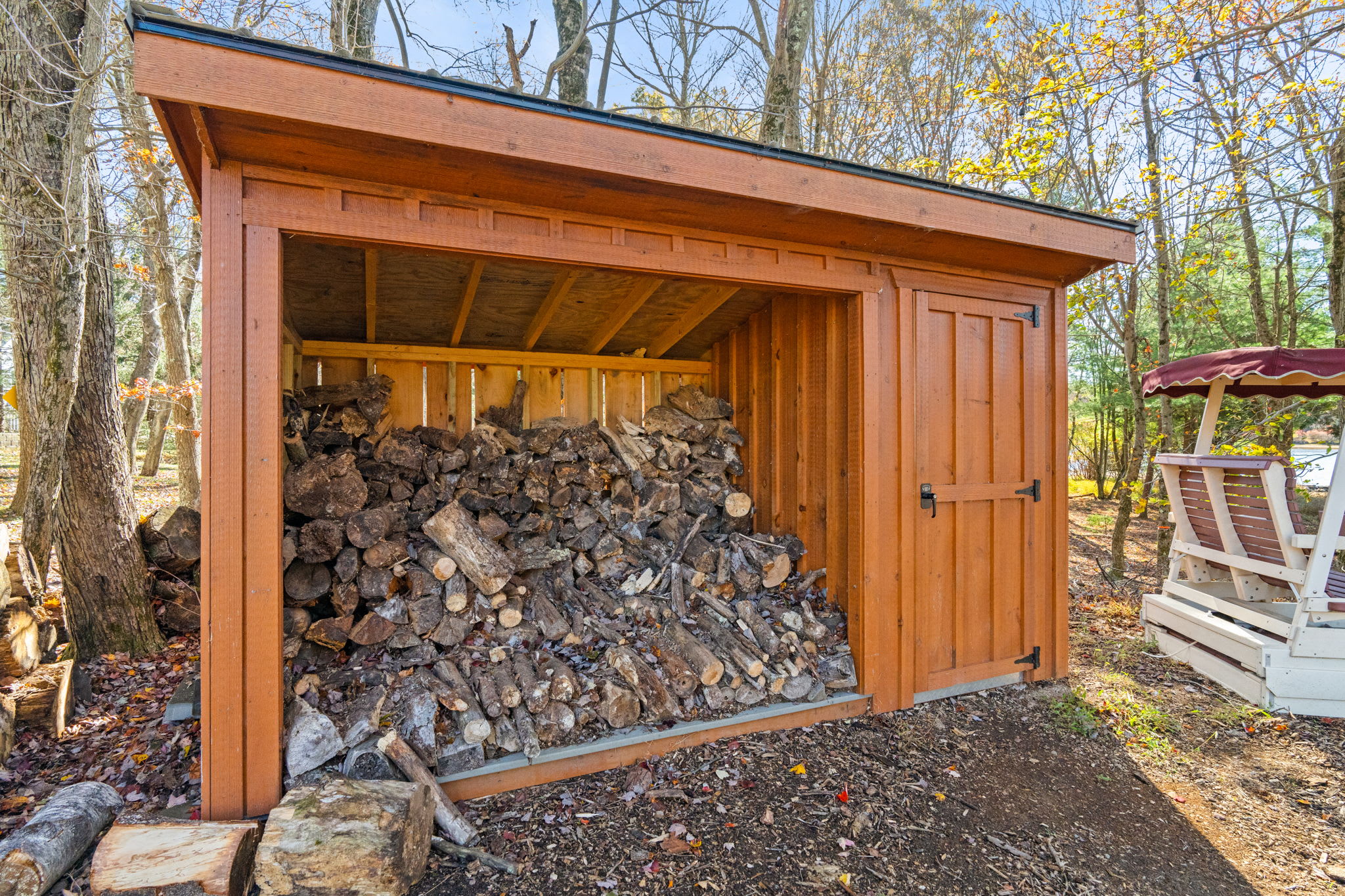 Stone-surrounded fire pit with Adirondack chairs - perfect spot for evening gatherings and marshmallow roasting