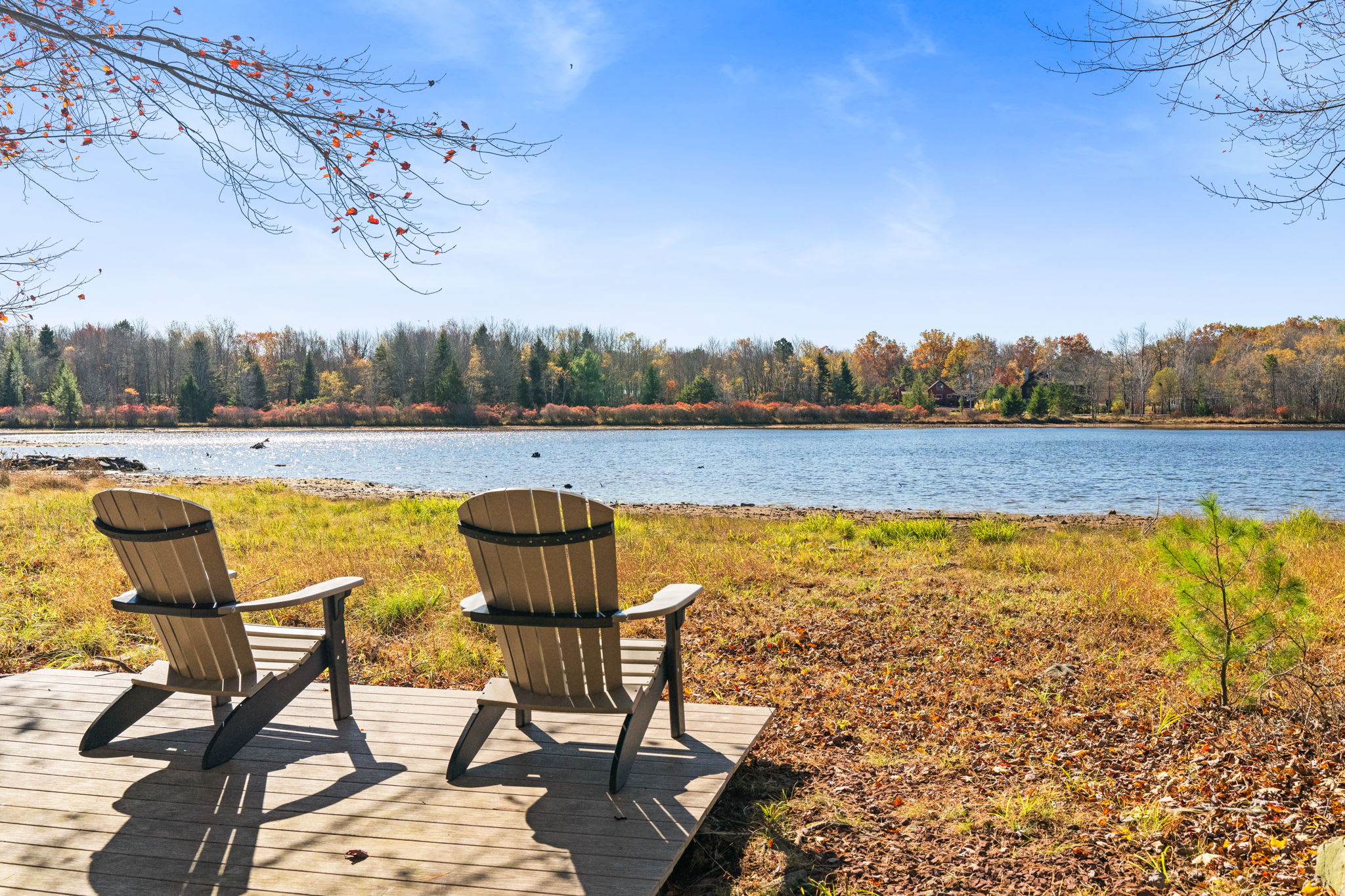 Lakefront relaxation with colorful Adirondack chairs and stunning water views - ideal for morning coffee and sunset watching