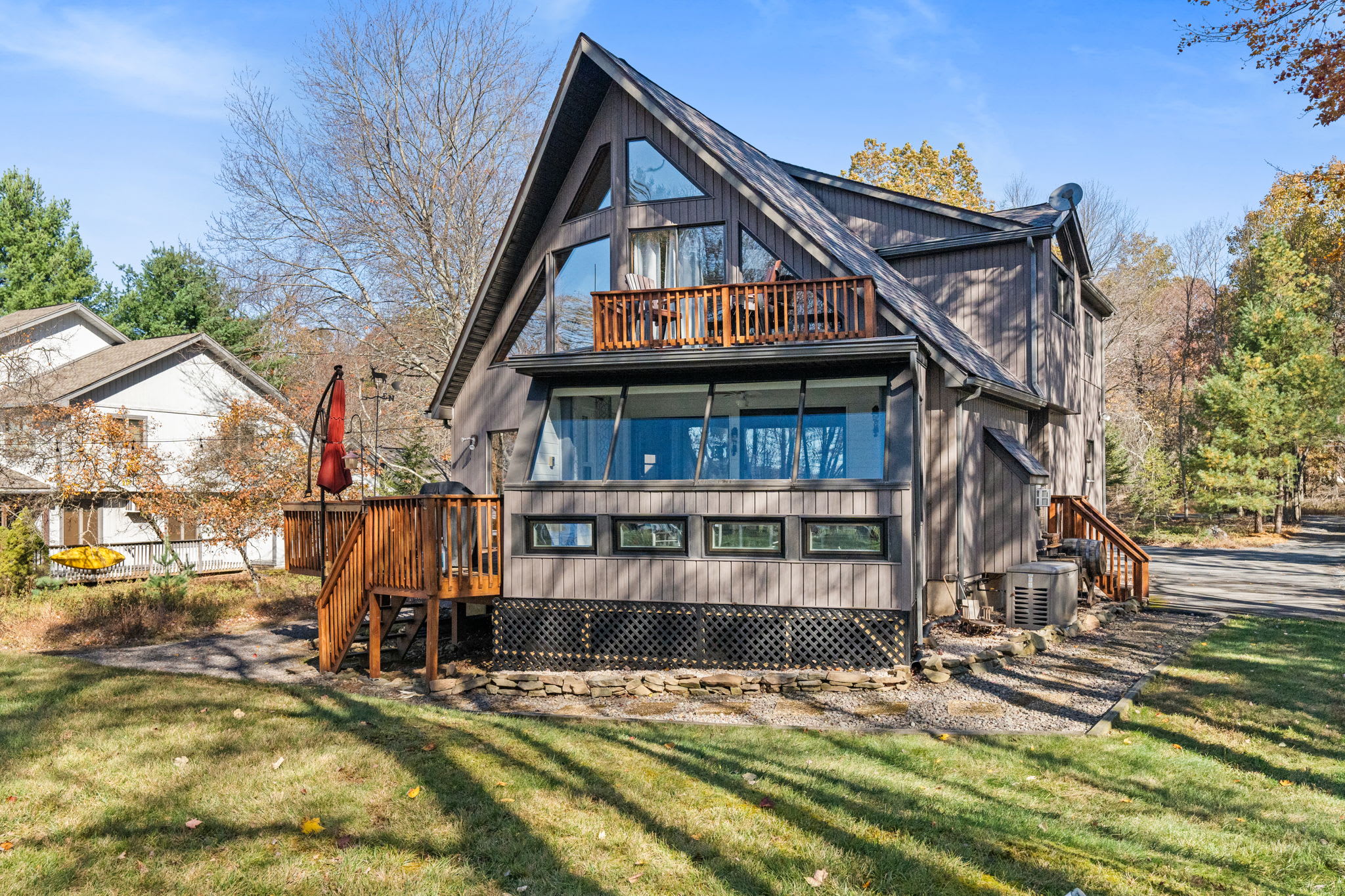 Beautiful lakefront A-frame home with spacious lawn, tiered decks, and private wooded setting - mountain retreat living